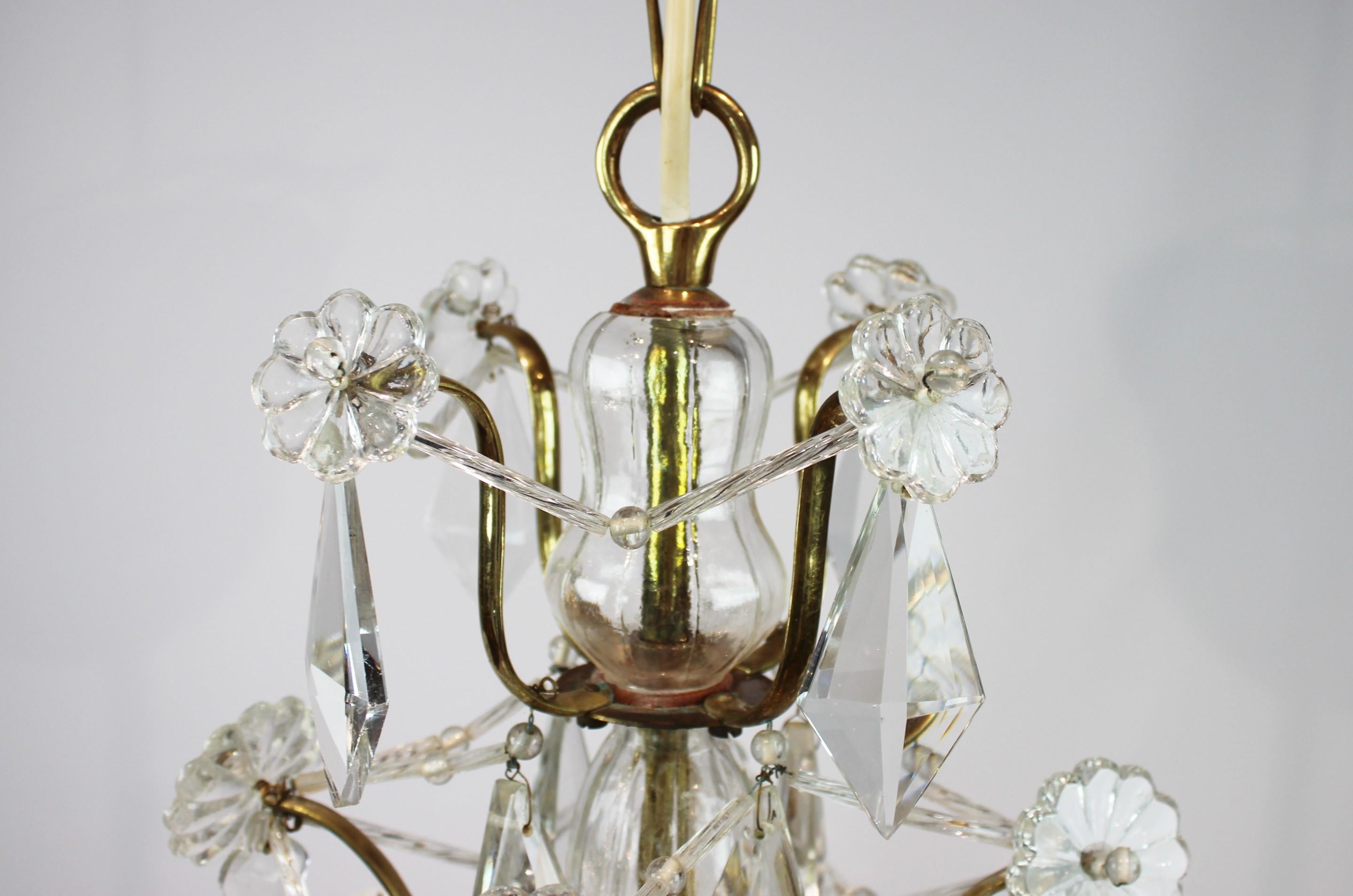 Chandelier of brass and polished prisms from France circa 1920s. The chandelier is in great antique condition.