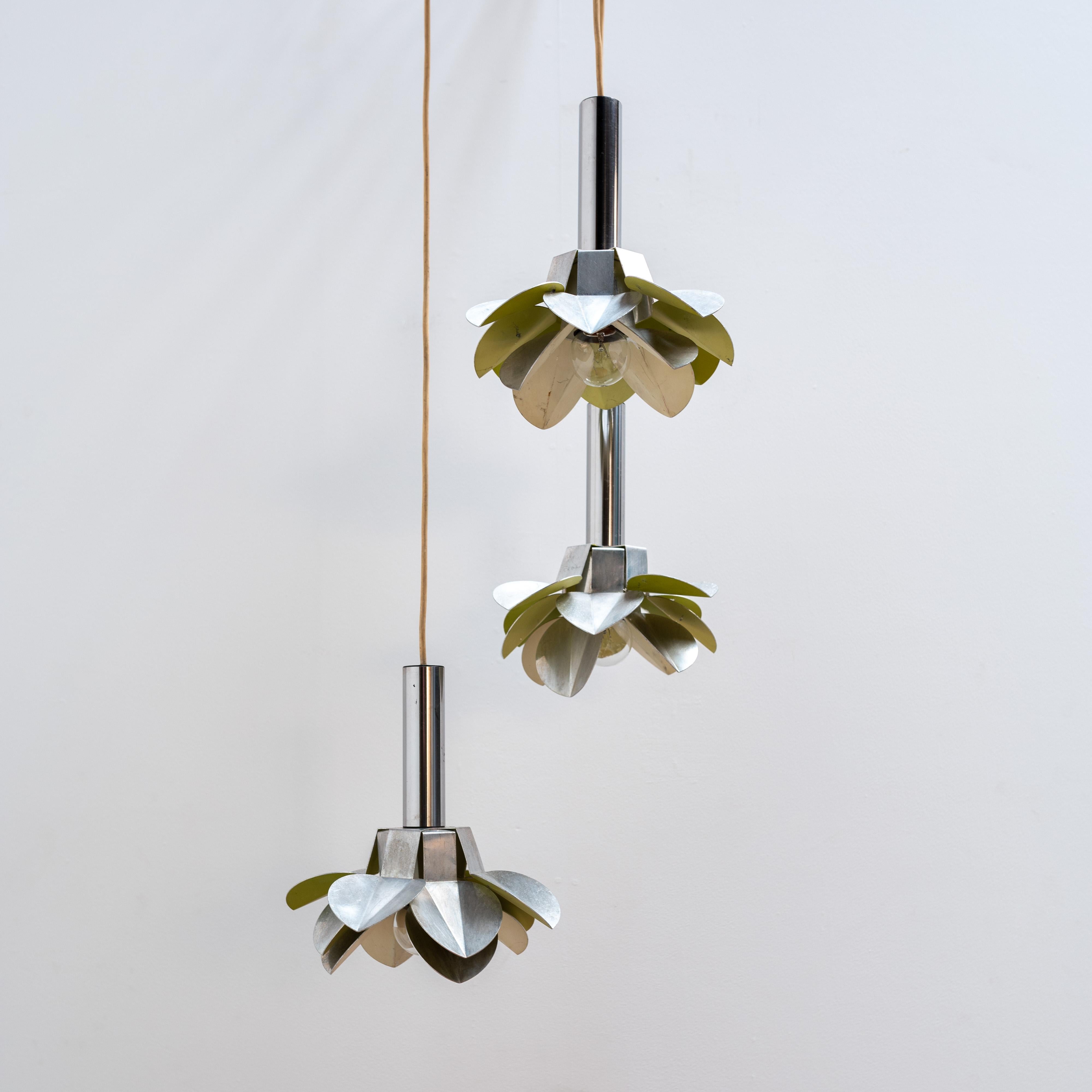 Pendentif élégant composé de trois fleurs avec une finition en métal. Ce design moderne intègre la répétition d'éléments naturels raffinés. En plus de fournir un éclairage fonctionnel, cette composition ajoute un style créatif et un accent vibrant à
