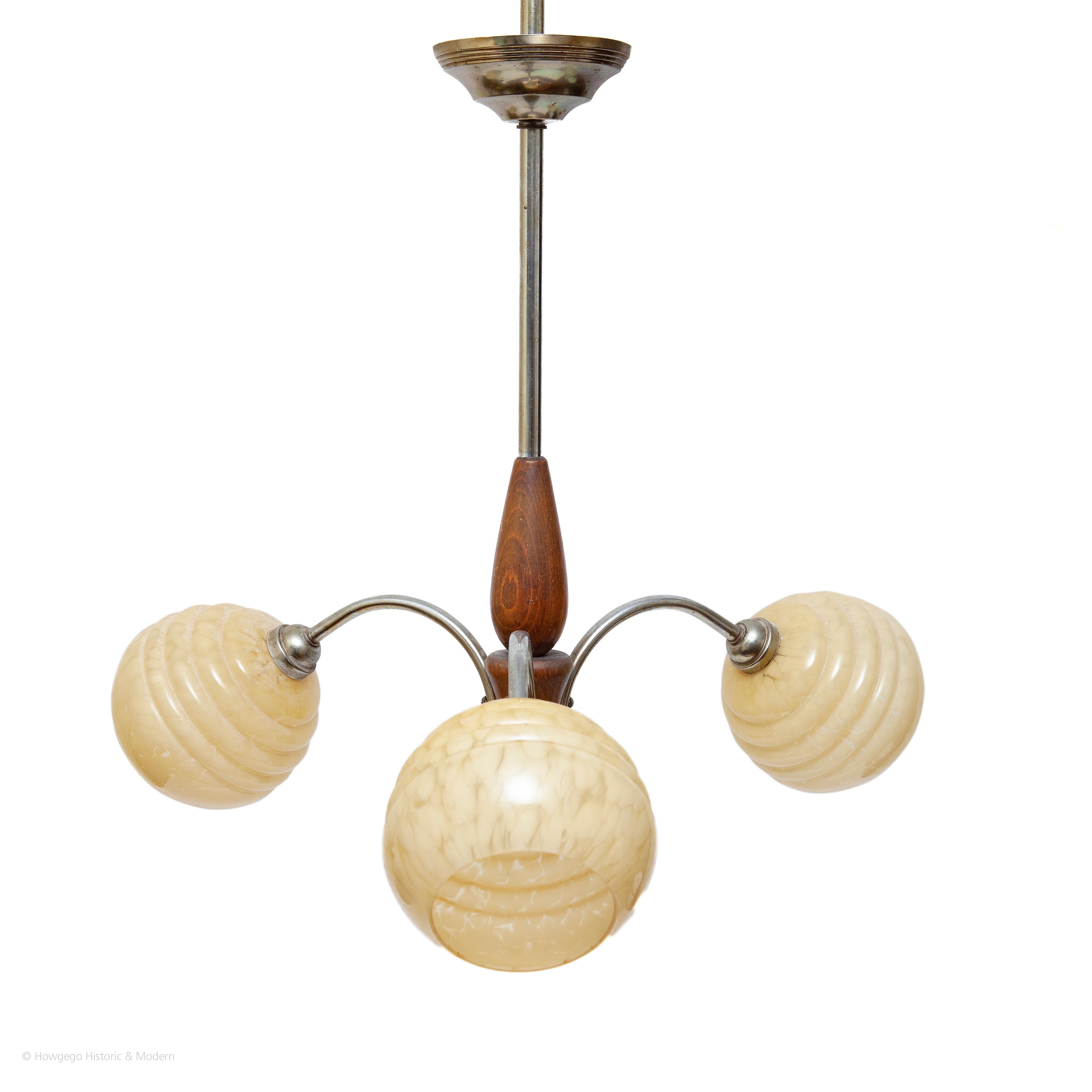 ART DECO, CHROME, TEAK AND GLASS PENDANT LIGHT WITH THREE ARMS/BRANCHES – 63.50cm., 25” high

Elegant, classic Art Deco form injecting the luxurious modernity of this period into the interior
The chrome, teak and glass create a balance of different