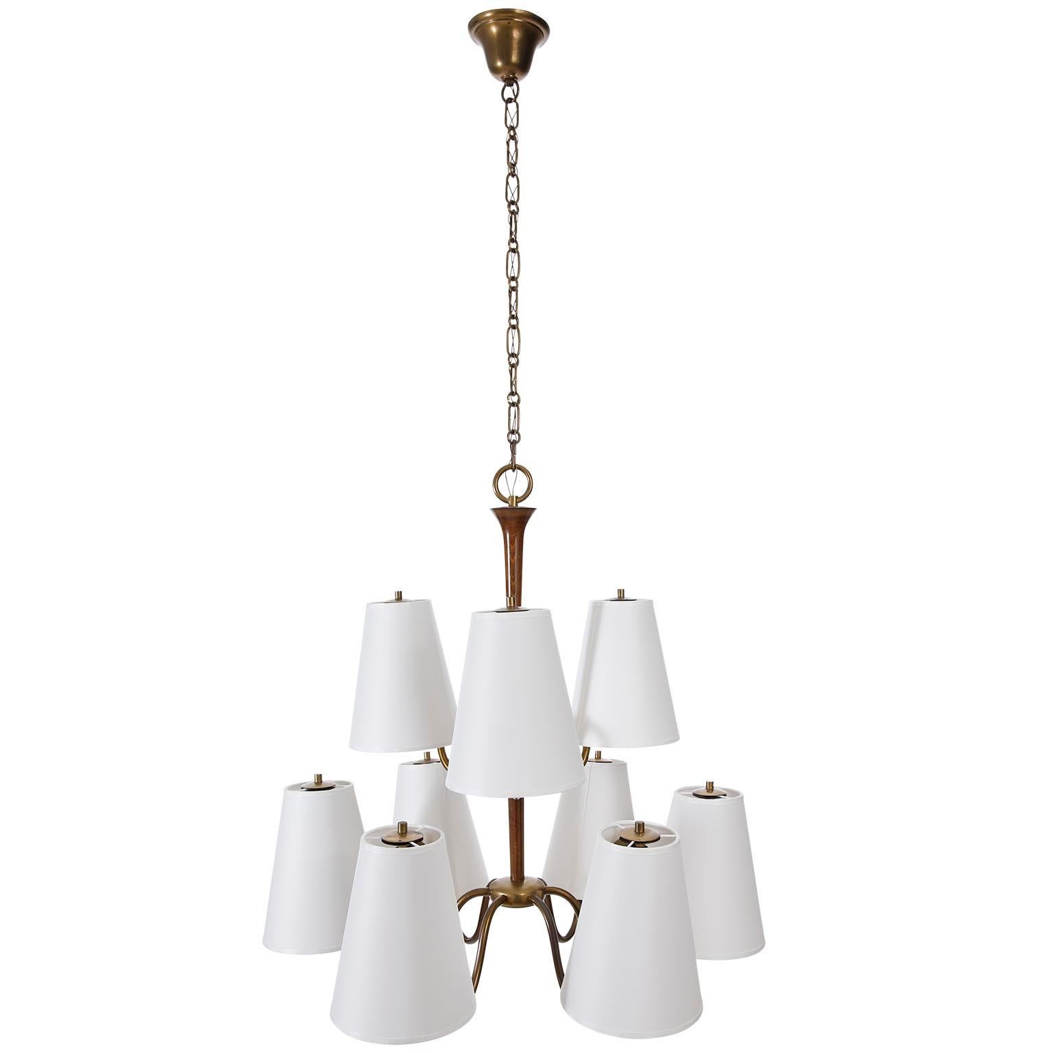 A 9-arm chandelier or pendant light attributed to Josef Frank, manufactured in 1930s.
It is made of wood and brass which got a wonderful patina during time.
The white lamp shades have been renewed on base of the original ones.
There are nine