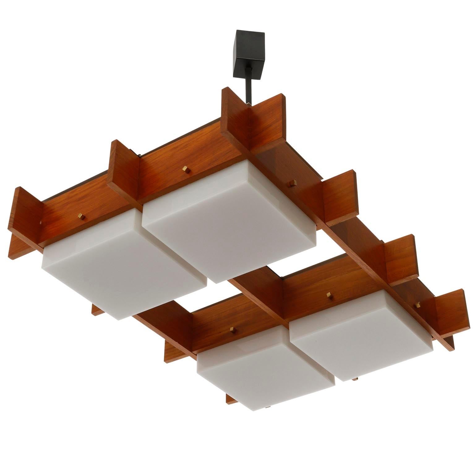 An Italian ceiling light fixture manufactured by Esperia in midcentury, circa 1960 (late 1950s or early 1960s).
The lamp is made of a warm and rich toned solid teak frame, opaline Lucite lamp shades, brass bolts and blackend iron.
The fixture has