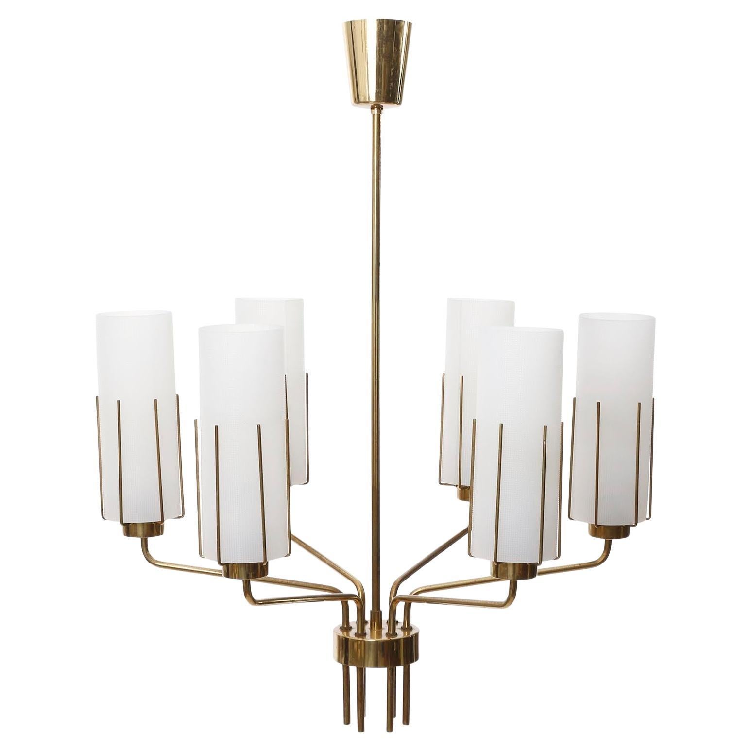 Un lampadario a 6 bracci del produttore austriaco di luci J.T. Kalmar prodotto a metà del secolo scorso, crica 1960.
La lampada è costituita da una solida struttura in ottone lucido con bracci curvi. Le parti in ottone presentano una patina.
Ogni