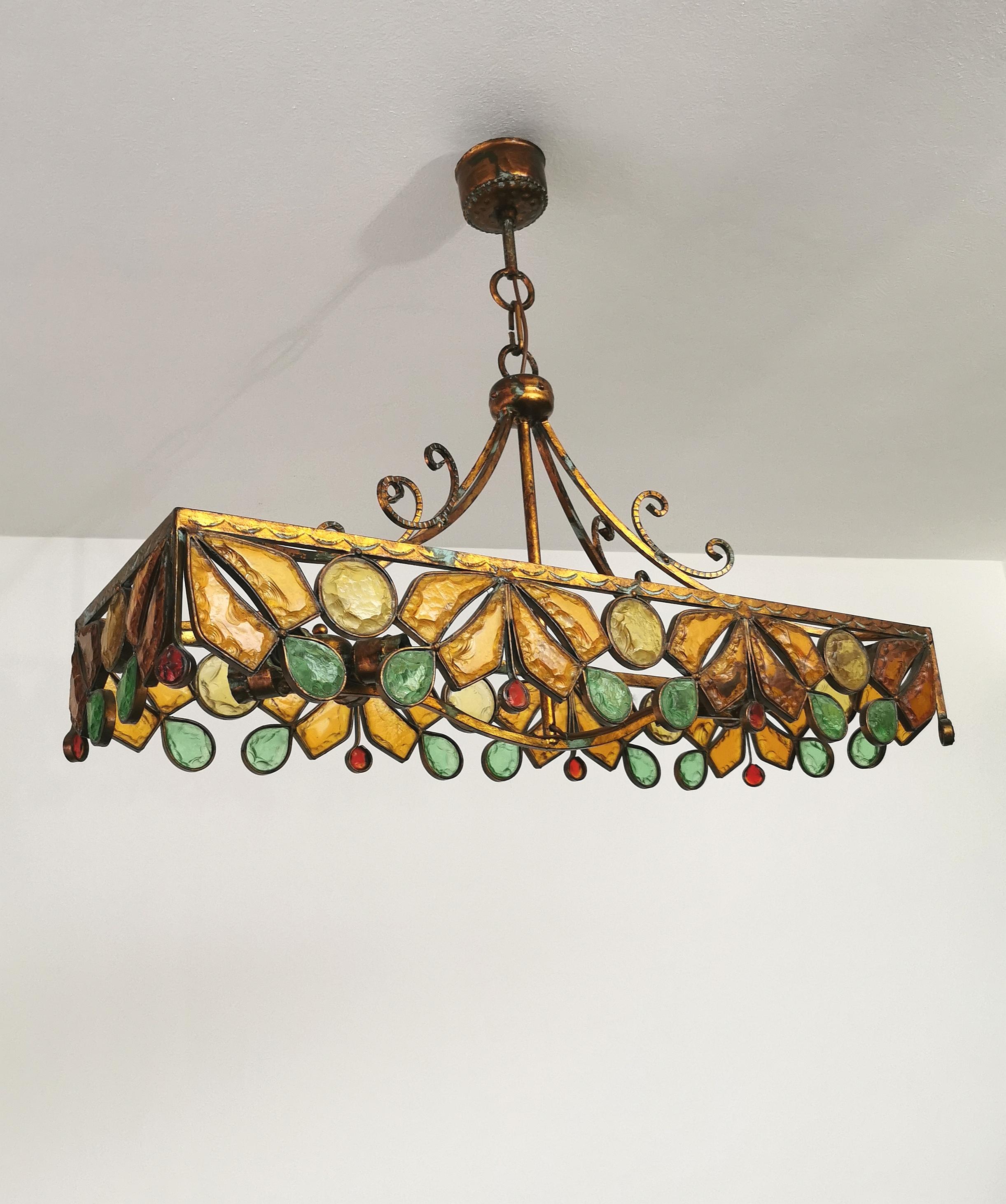 Large 8-light chandelier produced in Italy in the 1970s by Poliarte. The chandelier was made of bronzed metal decorated with thick hammered glass in shades of yellow, green, red and transparent.


Note: We try to offer our customers an excellent
