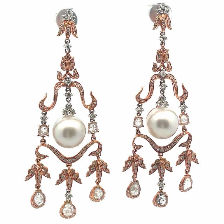 These 18-carat gold diamond chandelier earrings feature two beautiful south sea pearls in the center, these pearls are surrounded by white round diamonds in different sizes with 1.52 carats in weight. At the end of the chandelier design, you