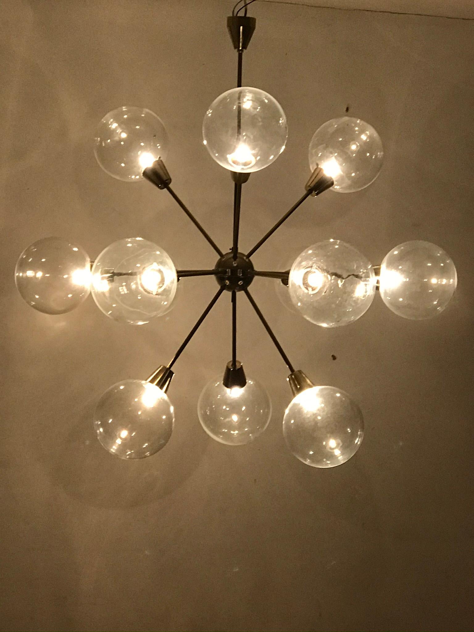 An unique chandelier from the 1975s. The brass construction is completed with the original patina. The glass balls are hand blown. The conditions is very nice. The chandelier is fitted with twelve glass spheres of 20 cm in diameter. Wiring is ready