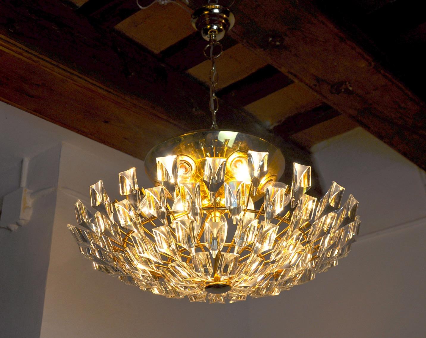 Superb and rare sun chandelier by Oscar Torlasco designated and produced in Italy in the 1980s.

This unique object is composed of cut crystals called triedri and a golden structure.

Object that will illuminate wonderfully and bring a real