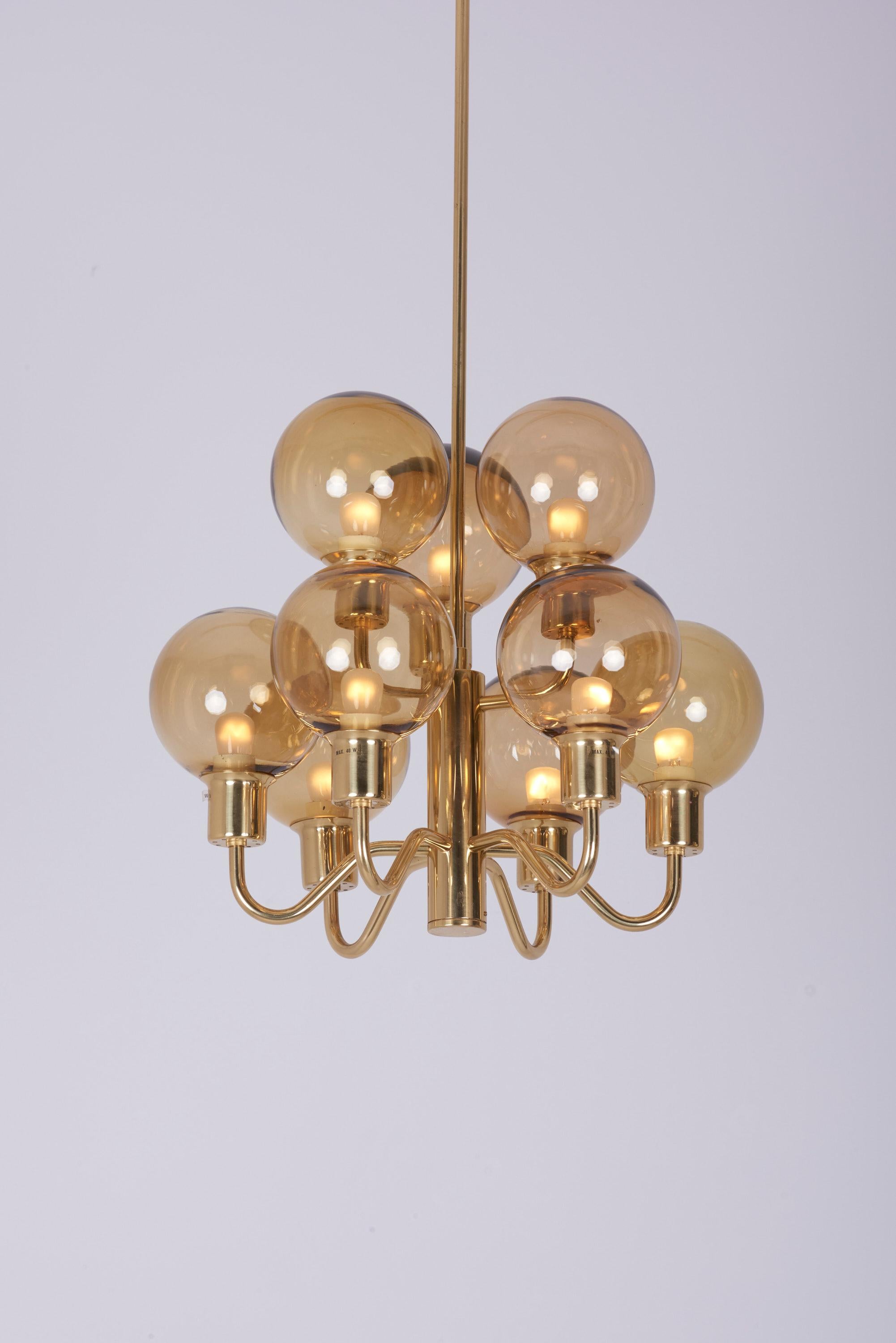 Brass and smoked glass ceiling lamp designed by Hans-Agne Jakobsson.
Produced in the 1960s by Hans-Agne Jakobsson AB in Markaryd Sweden.
9 x E 14 bulbs.

To be on the safe side, the lamp should be checked locally by a specialist concerning local