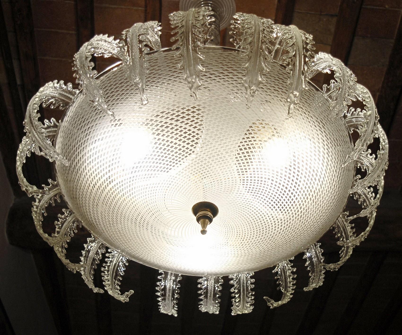 A beautiful chandelier, carries the largest reticello disc I have ever seen or could be found on auctions or other fine dealers. The great reticello bowl is surrounded and crowned by 24 clear leaves that are topping the chandelier and making a