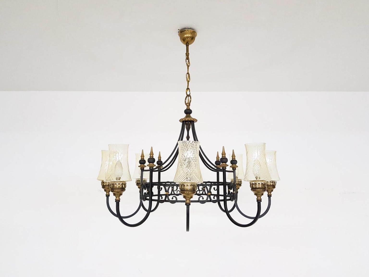 Impressive black iron chandelier with brass details and beautiful hand blown glass chalices from the 1930s.

This chandelier had a prominent place above a large round table in a Dutch mansion. There it hung for almost a 90 years. When we saw its