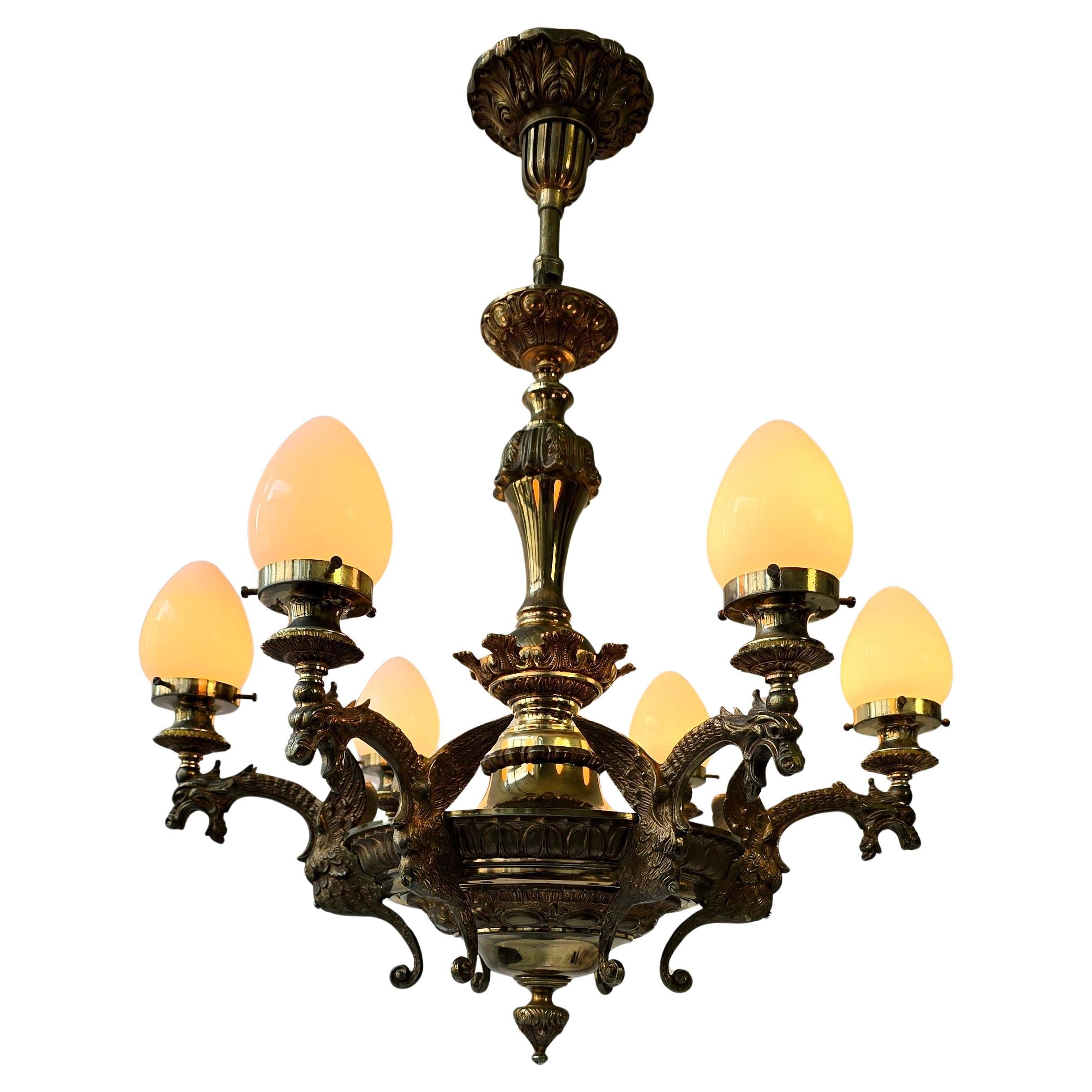 Esclusivo lampadario French con draghi e paralumi in vetro opalino - Mid 20th Century

Un bellissimo lampadario francese della metà del secolo scorso. Il lampadario è realizzato in ottone massiccio con una patina ricca e calda che ne sottolinea