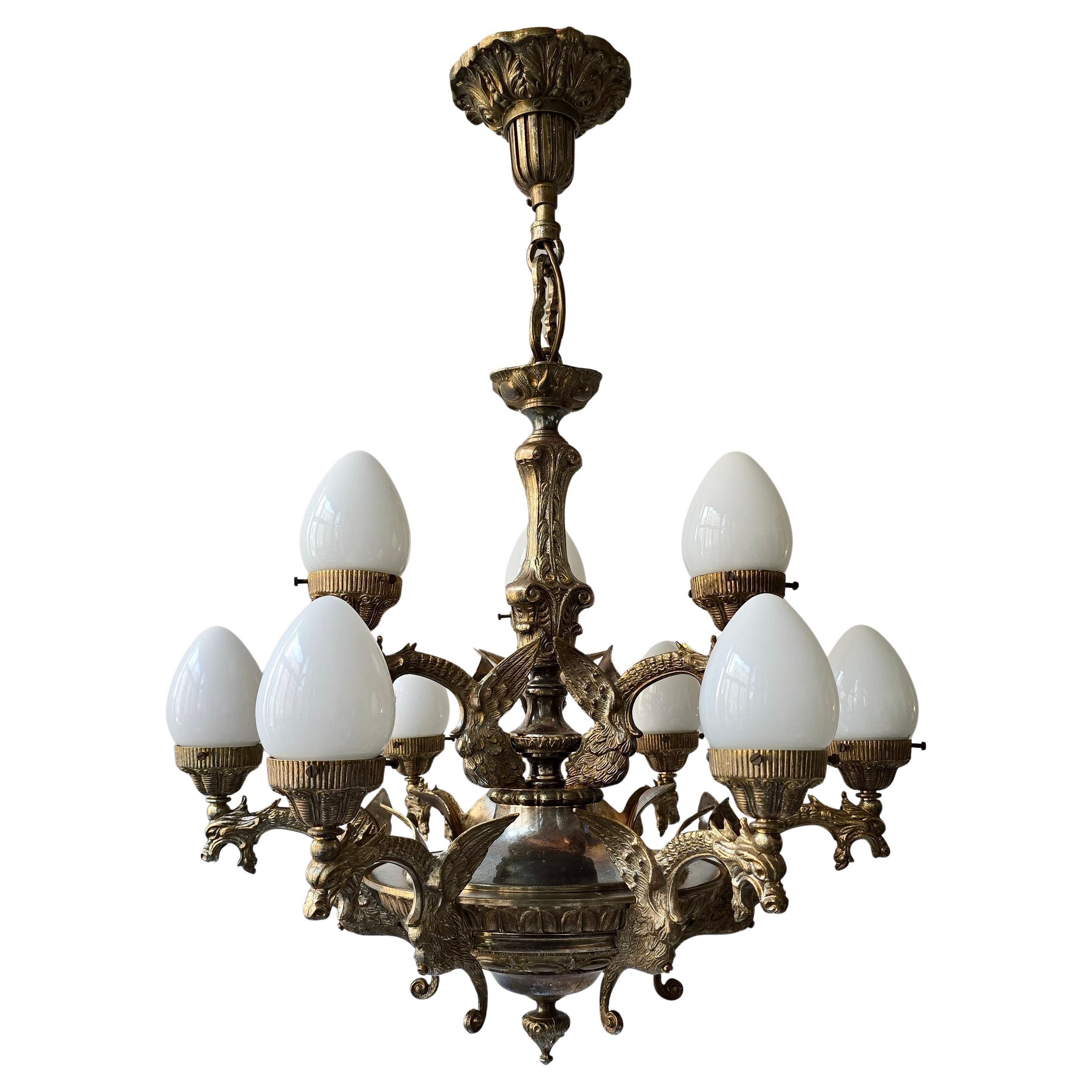 Lustre français exclusif avec dragons et abat-jour en verre opalin - Milieu du XXe siècle

Un beau lustre français du milieu du siècle dernier. Le lustre est fabriqué en laiton massif avec une patine riche et chaude qui souligne son authenticité et