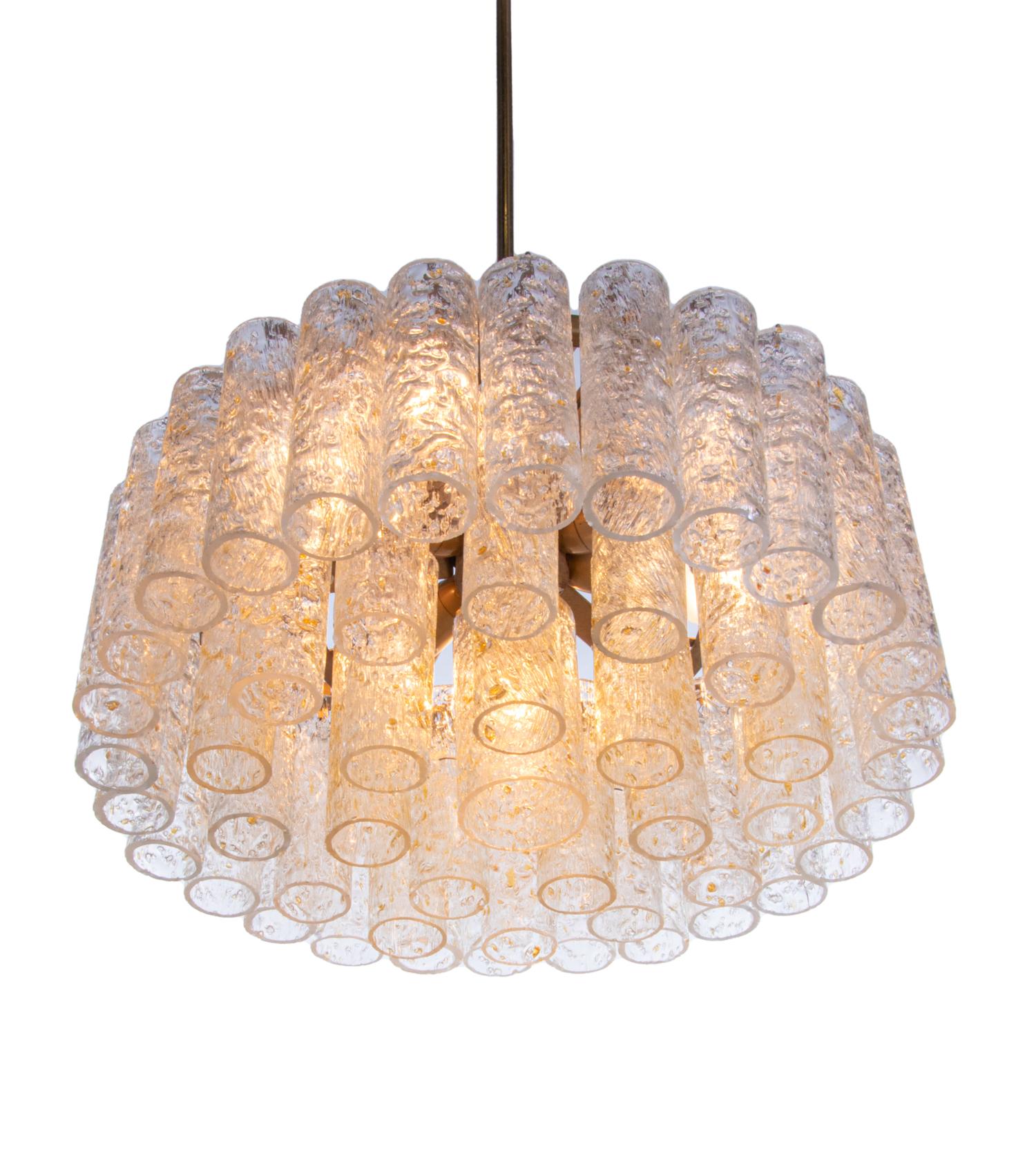 Eleganter, kaskadenförmiger Kronleuchter mit goldglänzenden Murano-Glasröhren auf einem Messingrahmen. Der Kronleuchter leuchtet wunderschön und spendet sehr viel Licht. Schmuckstück aus der Zeit. Mit dieser Leuchte setzen Sie ein klares Statement