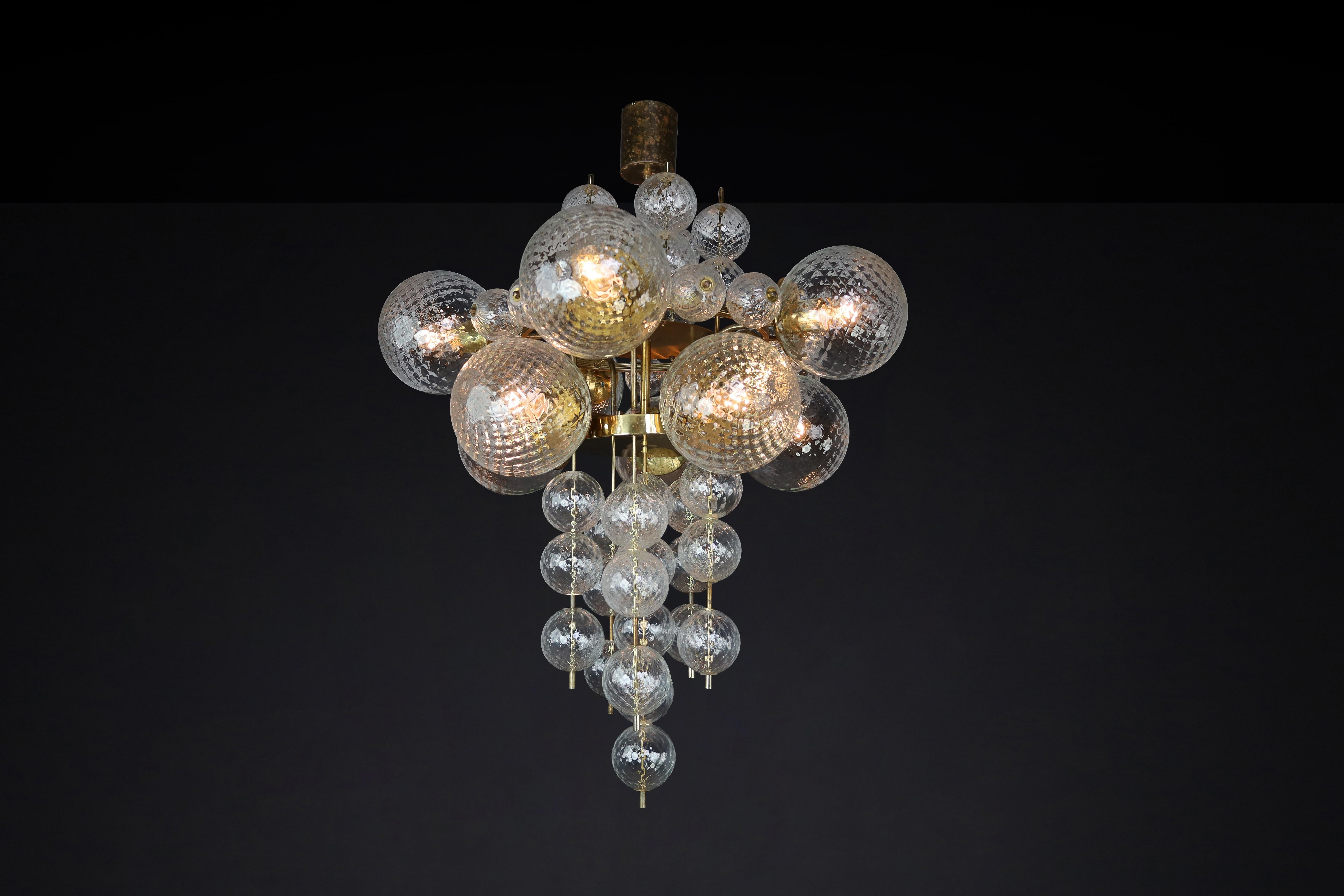 Large Chandelier with Patinated brass fixture and hand-blowed glass globes by Preciosa, Czechia, 1960s

This Chandelier was made in the 1960s and is from a grand hotel in Prague. It features a patinated brass fixture and hand-blown glass globes