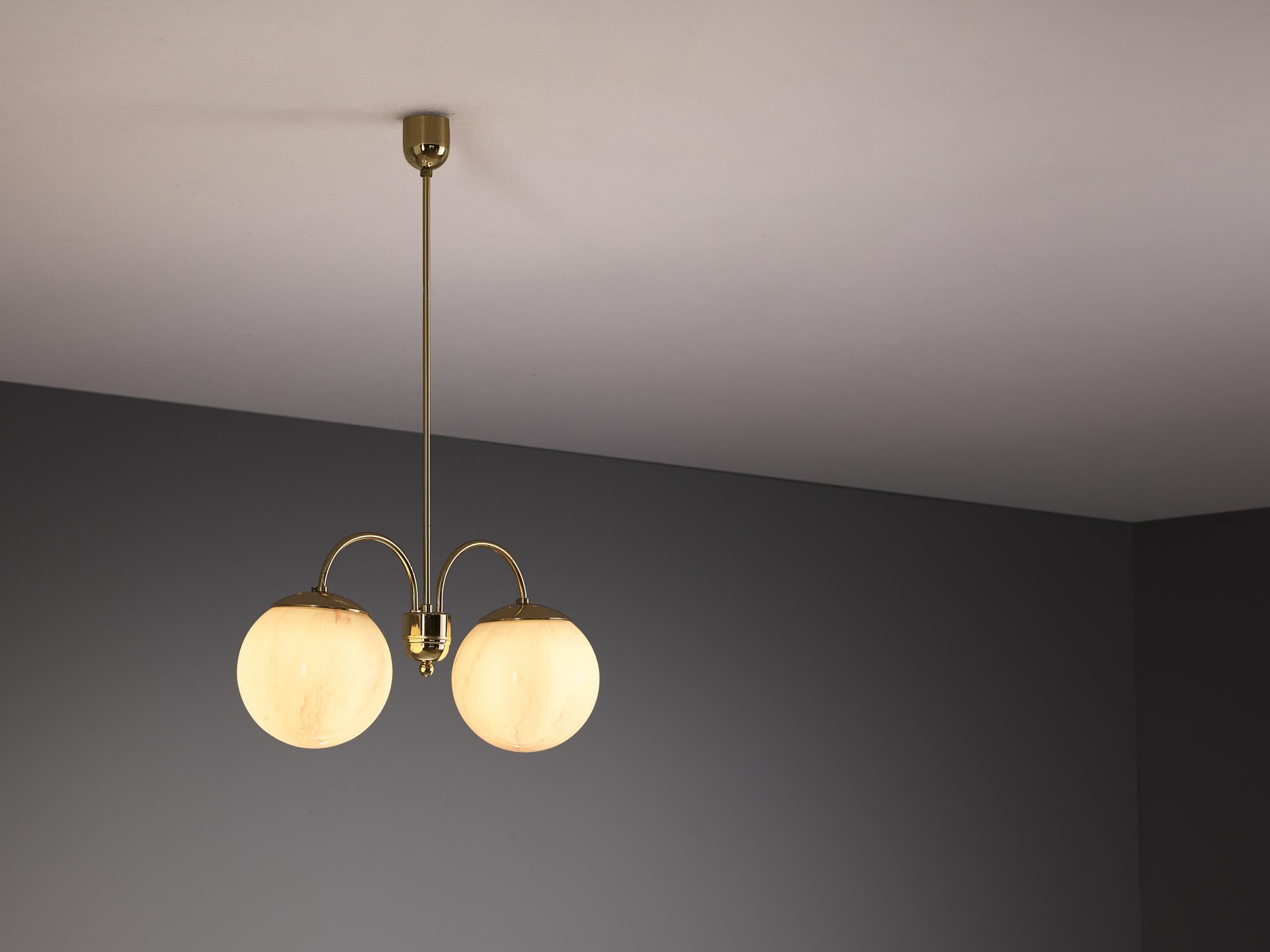 Chandelier, glass, brass-plated steel, Czech Republic, 1960s

This refined chandelier has a nicely structured composition of two spherical shades attached to a patinated brass frame. The glass resembles the visual qualities of marble, displaying