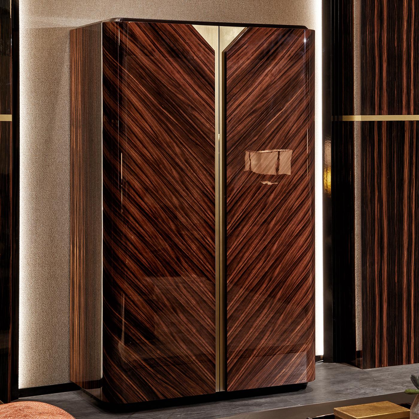 Natural beauty is the central element of the Chandler Cabinet, designed for warm, contemporary living spaces. Crafted in wood, the cabinet features Macassar ebony veneer carefully positioned to create a chevron design, exalted by a glossy finish.
