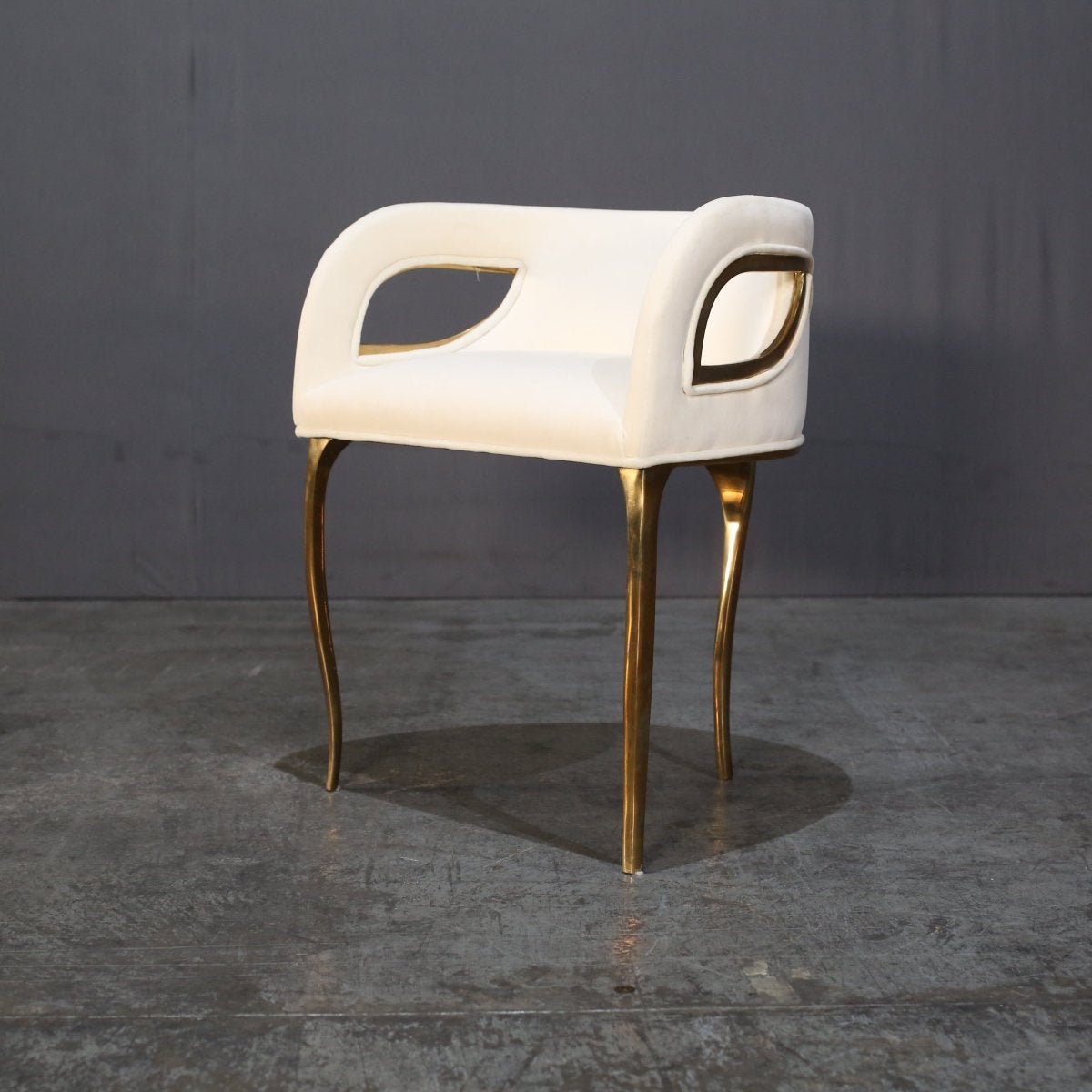 Ti presentiamo la splendida sedia Chandra di Koket, un'aggiunta di lusso a qualsiasi casa. Questo pezzo pregiato presenta un design elegante e moderno, con uno schienale curvo e un'imbottitura color crema. L'ottone aggiunge un tocco di glamour e