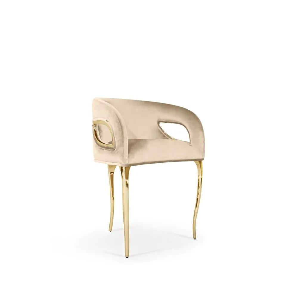 Chandra est à la fois audacieuse et téméraire. Le bord moderne de cette chaise dégage une sensation de glam vintage, tandis que des bandes métalliques lient délicatement la chaise en soulignant la fluidité sculptée du rembourrage serré du dossier.
