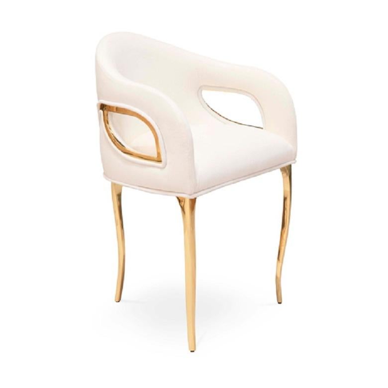 Chandra ist sowohl kühn als auch wagemutig. Die moderne Kante dieses Esszimmerstuhls strahlt das Gefühl von Vintage-Glam aus, während Metallbänder den Stuhl zart zusammenhalten und die fließende Form der engen Rückenpolsterung hervorheben.