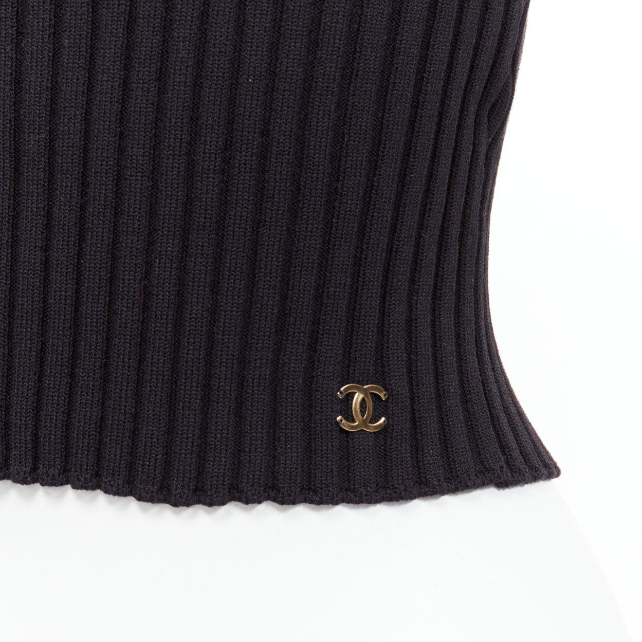 Chanel 01A charm d'oro con logo CC  canotta nera a coste con scollo a V FR38 M.
Riferimento: CNLE/A00219
Marchio: Chanel
Designer: Karl Lagerfeld
Collezione: 01A
Materiale: Nylon
Colore: nero
Modello: Tinta unita
Chiusura: Slip On
Dettagli extra: