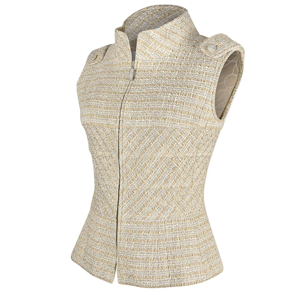 Mightychic offers a Chanel 01P sleeveless vest /top in warm nude toned tweed.
Subtle silver metallic thread accentuates the beauty of this piece. 
High stand away neck - very dramatic without being overwhelming.
The front center zipper pull Chanel