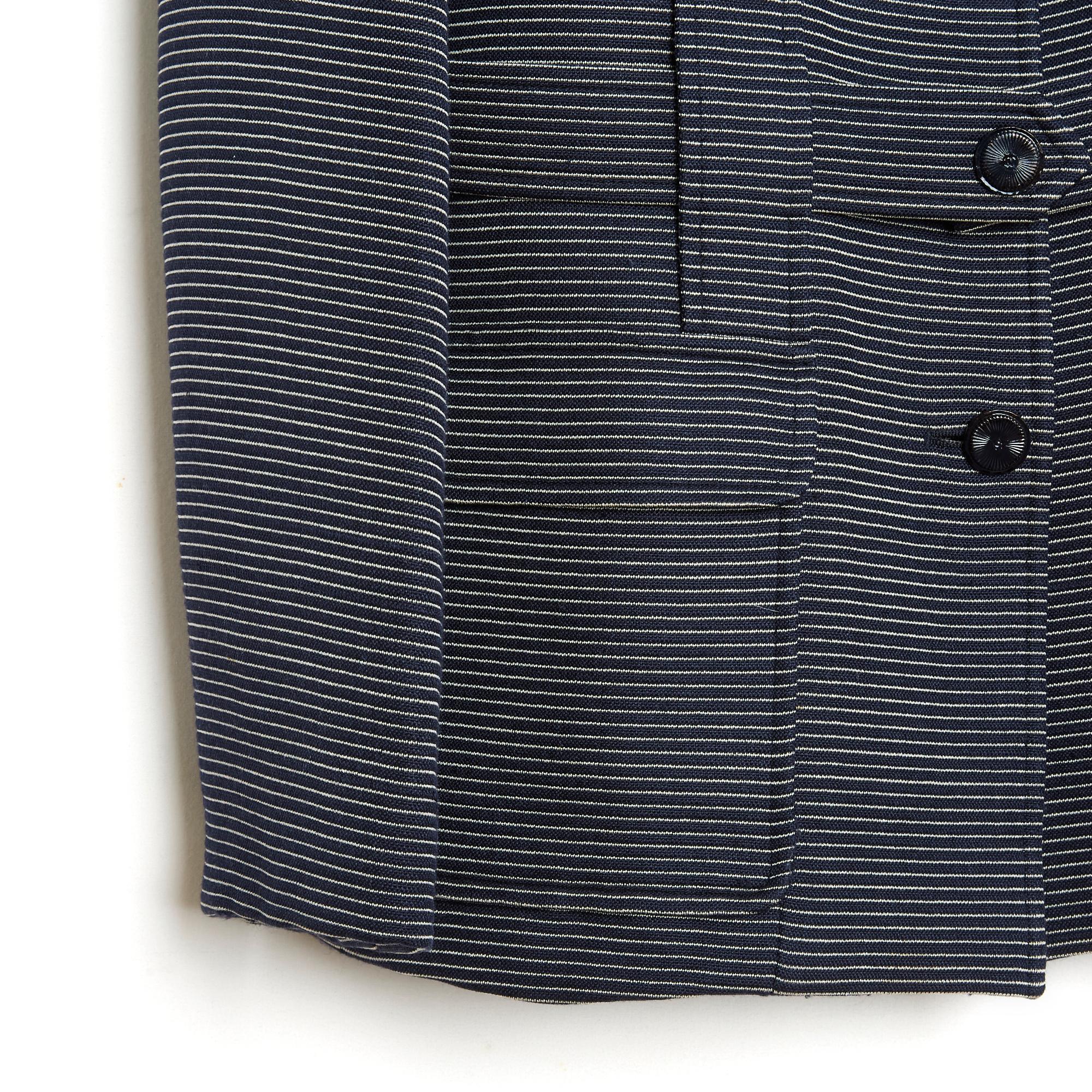 Chanel jacket from the SS2001 collection by Karl Lagerfeld in navy blue wool cloth, almost black, striped with white thread, notched collar closed by 4 painted metal buttons with CC logo, matching belt on belt loops (invisible) and closed by an
