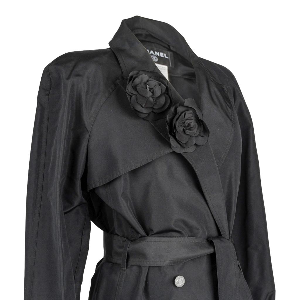 Chanel 03C stunning trench style Silk taffeta coat.
Jet black 2 on 4 button double breast with a notch lapel.
2 beautiful silk detachable black camellia pins on the right lapel.
Self belt with a square black enamel buckle with CHANEL embossed. 
Cuff