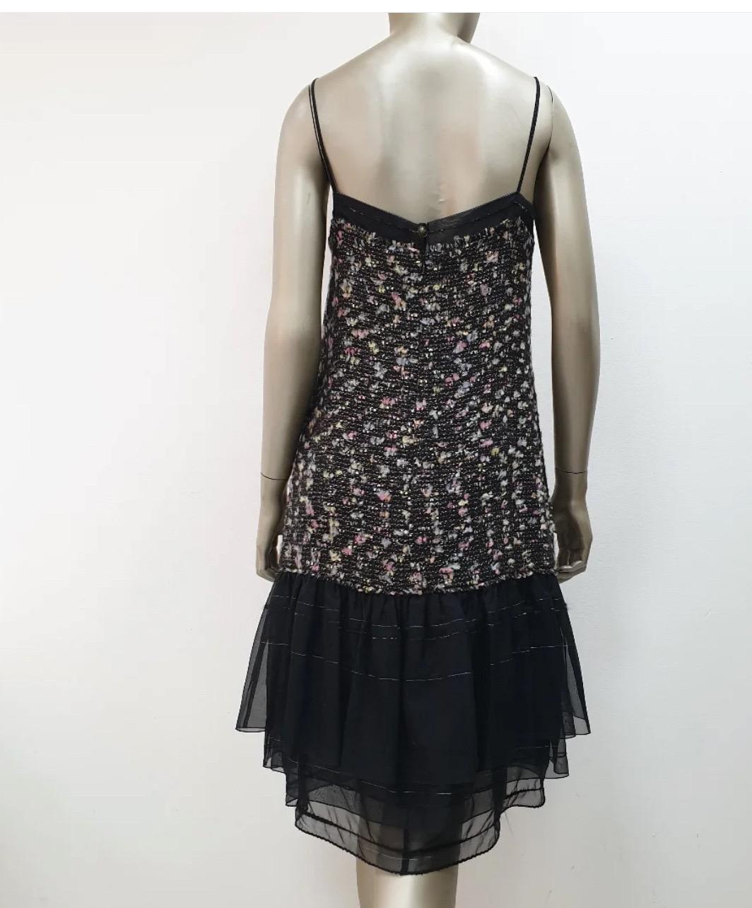 Questo è un bellissimo completo Chanel a due pezzi della taglia 44 della collezione 04A! 

Include un abito e una giacca, entrambi realizzati in tweed di alta qualità e impreziositi da bordi in chiffon e nastri. L'abito è in ottime condizioni e non