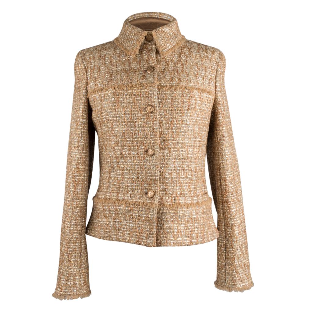 Guaranteed authentic Chanel 05P metallic gold and silver toned tweed single breast jacket.
Rich fabric pattern accented with fringe trim. 
2 faux slit pockets at waist. 
5 beautifully embossed gold buttons with interlocking CC in front and 3 working