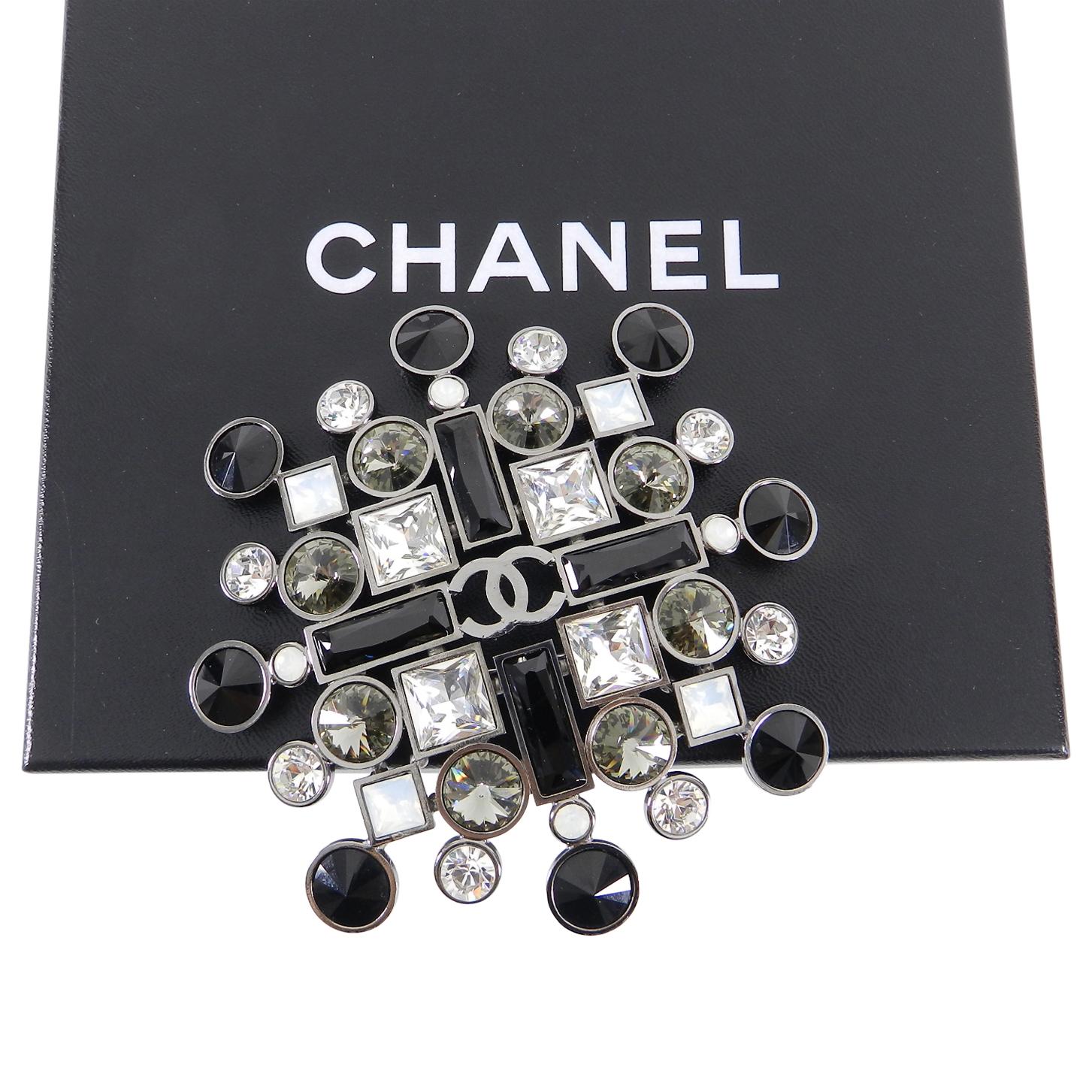 Chanel 06A Large Black, Clear, Grey, Crystal Statement Brooch Pin.  Dark gunmetal base with faceted crystal jewels and CC logo at centre.  Extra large statement size measuring 4-⅛” x 4-⅛”. Has a bale at back above pin-back to be worn as a pendant.