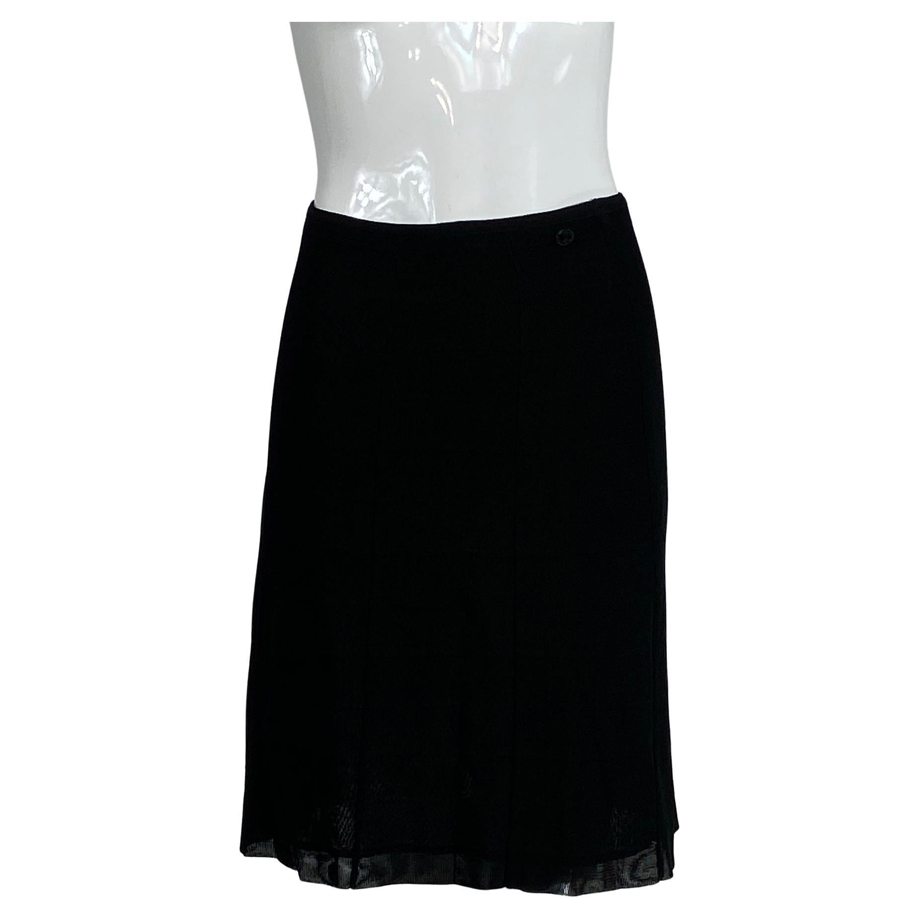 Chanel 07C black gored rib knit skirt. Pull on skirt, with a cased elastic waist band and a Chanel black logo sewn at the waist side front. Seamed gored skirt with a horizontal band knit pattern. The skirt is lined in black mesh. Marked size 36. 
  