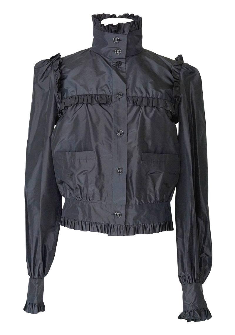 Mightychic offers a Chanel 07C silk faille jacket.
Stunning jet black silk taffeta sporty jacket with ruffle detail.
7 Button single breast.  
Open work buttons have a CC center.
Mandarin collar with ruffle edge.
Across the chest, around the