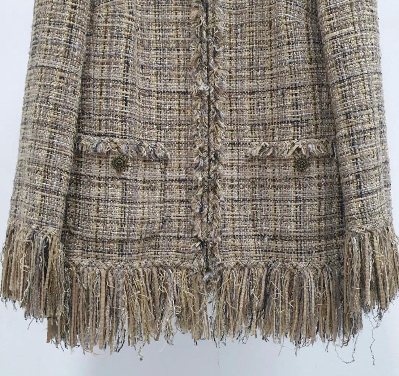 From the Fall 2010 Collection. Tan and multicolor Chanel Lesage tweed jacket featuring woven leather strips and fringe trim throughout, Structured shoulders, dual patch pockets featuring interlocking CC button closures and concealed zip closure at