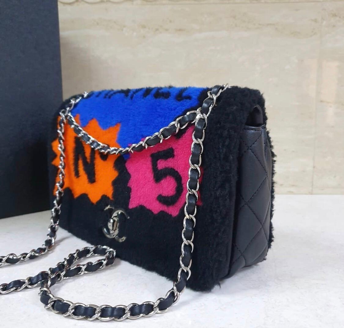 Chanel 14A Patchwork No. 5 Caption Comic Shearling jumbo flap bag in black. 
Limited edition bagю
Comic text design in hot pink, orange, yellow, and blue.
Soft shearling exterior with quilted lambskin body.
Jumbo size measuring  28*15*8 cm
Dust bag