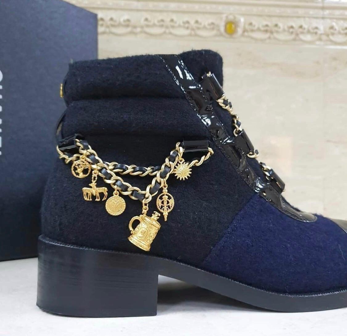 Chanel Paris Salzburg Charm Ankle Boots from the Pre-Fall 2015 Métiers d'Art Collection Crafted in wool and a patent toe cap and trim. Designed with interwoven chainlink detail as a lace up front and sides. Features ornate charm detail on right