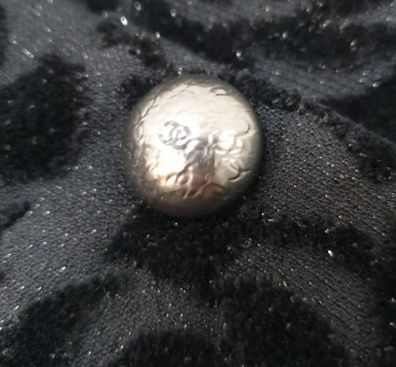 Absolument magnifique veste Chanel 18A Hamburg ! Cette veste fantaisie en tissu éponge noir est ornée d'une fleur de camélia et du logo CC. Le tissu a une légère brillance qui le rend très joli. 

En excellent état d'usage, avec une légère usure. Il