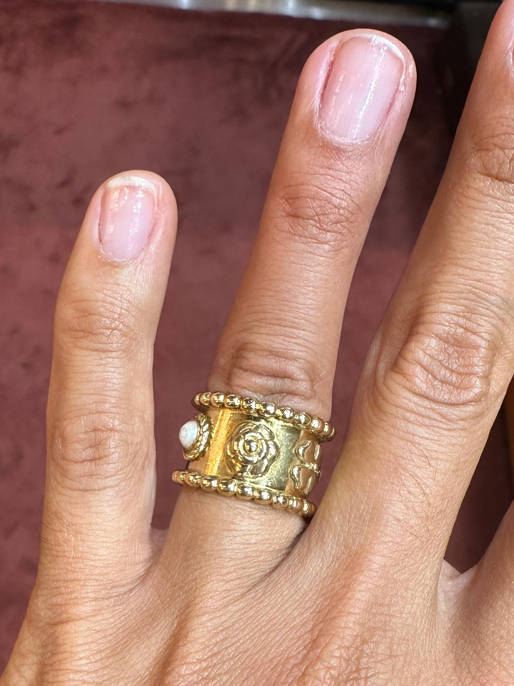 Fabulous Chanel 'Camelia' Ring. Its 18k yellow gold band has been masterfully crafted with exterior floral designs and parallel bead-style borders on either side, while its matching top and bottom pearls conclude its fine sense of symmetry. Of