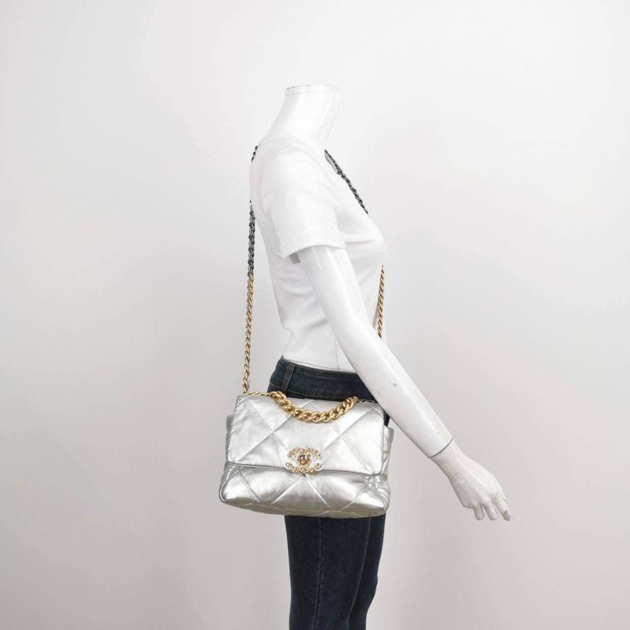 Chanel 19 Bolso Crossbody Pequeño Plateado Éstas son fotos profesionales del bolso real ofrecido por Luxbags. El bolso Chanel 19 fue el último diseñado por Karl Lagerfeld. Posee un trozo de historia a través de esta bolsa. Su piel y su forma