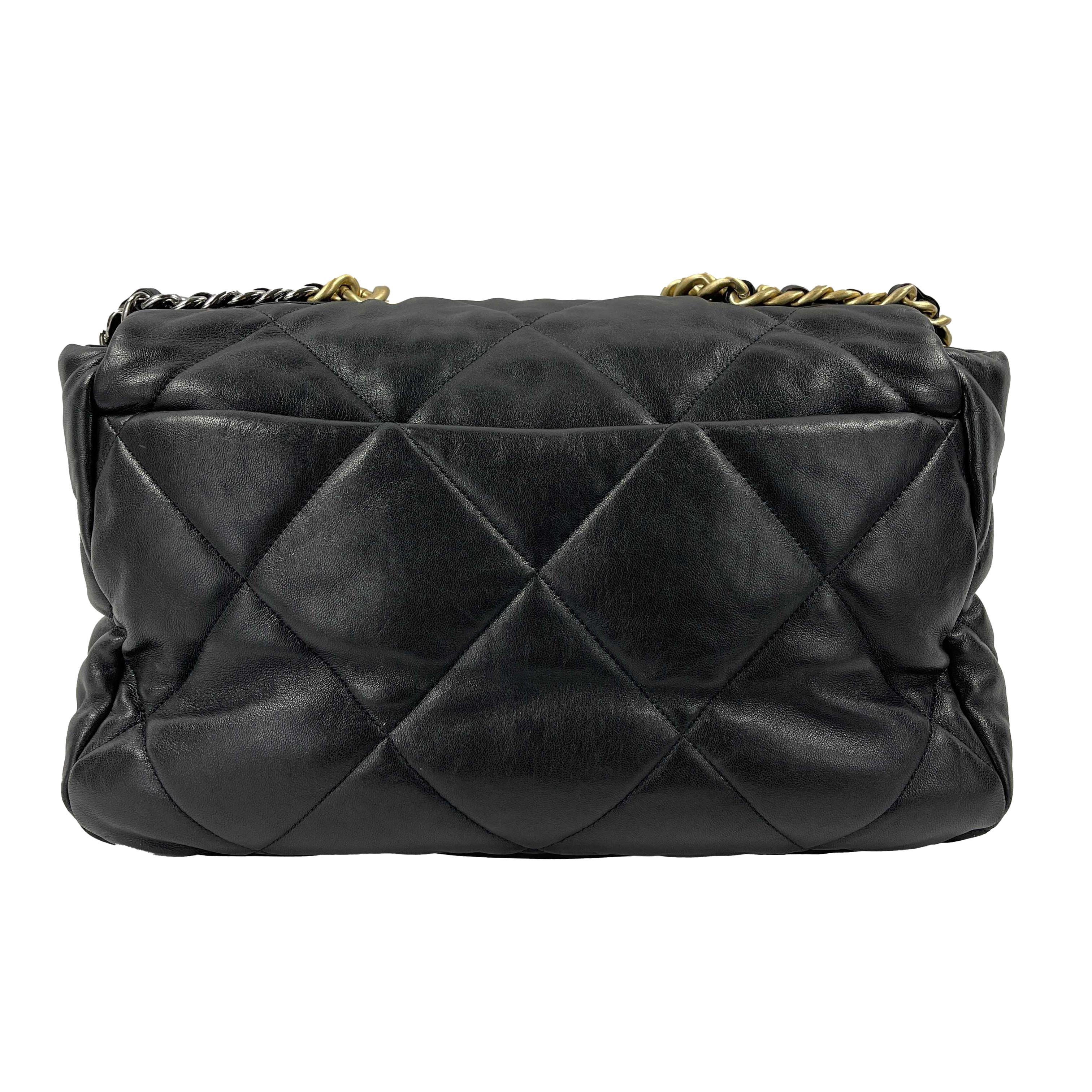 This Chanel flap handbag is from the 2020 collection.
It is crafted with black quilted stitched lambskin leather.
The backside contains a large pocket with a magnetic closure and is lined in red grosgrain fabric.
It opens using a gold-toned