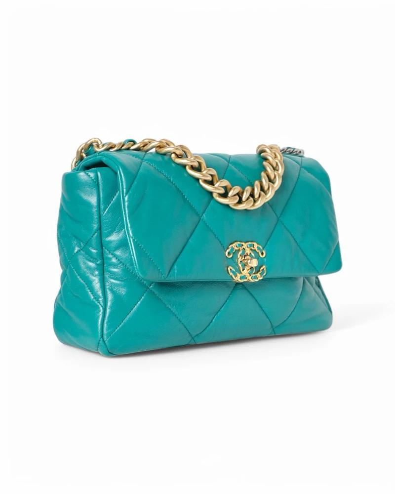 Bolso de la firma Chanel, modelo 19 Flap, en tamaño Large, realizado en piel acolchada en un refinado color turquesa con herrajes bicolor, dorado/plateado. La solapa delantera está decorada con el clásico logotipo 