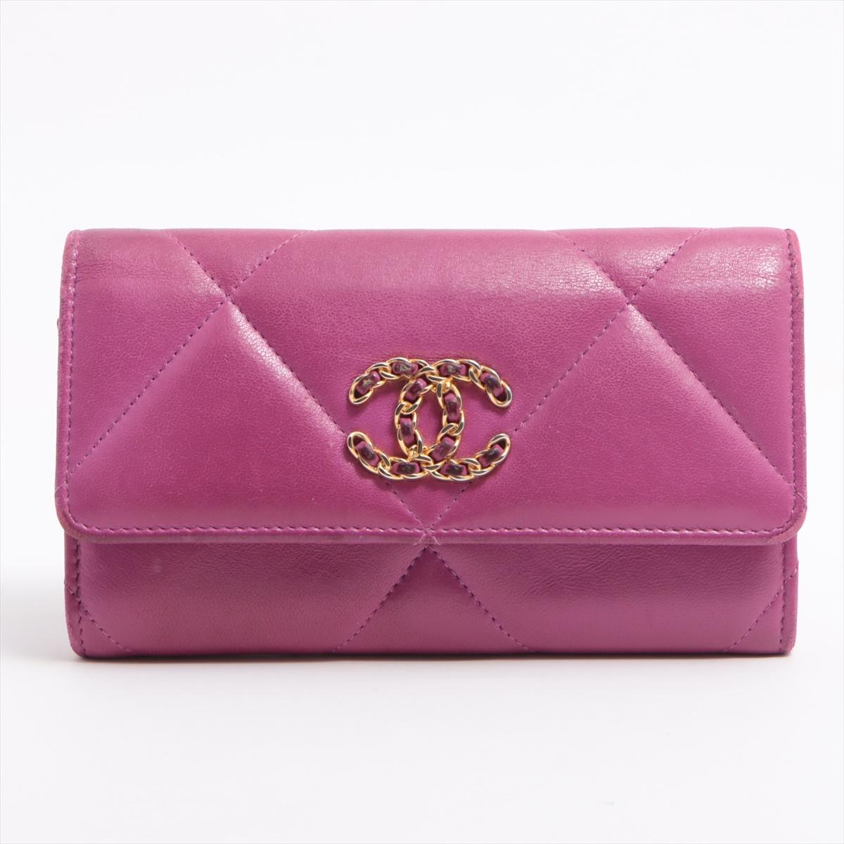 The Chanel 19 Lambskin Compact Medium Wallet in Purple is an exquisite accessory that embodies the essence of luxury and sophistication. Crafted from supple lambskin leather, the wallet features Chanel's iconic diamond quilting, lending it a