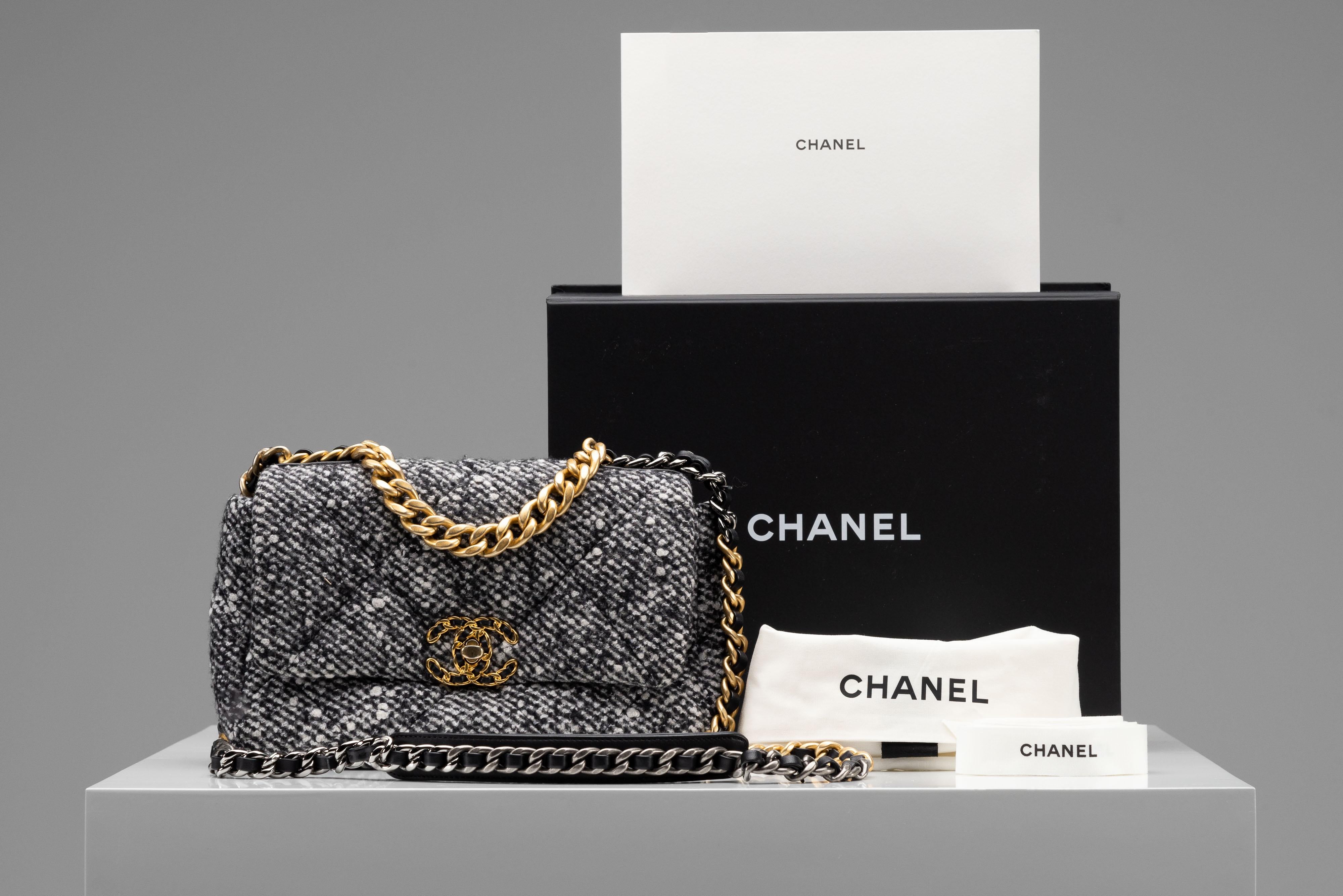 From the collection of SAVINETI we offer this Chanel 19 Flap Bag:

- Brand: Chanel
- Model: 19 (Small/ Regular 26cm)
- Color: Tweed (Black/ White/ Grey)
- Year: 2021
- Condition: Excellent 
- Materials: Tweed, Gold-Color Hardware
- Extras: Full-Set