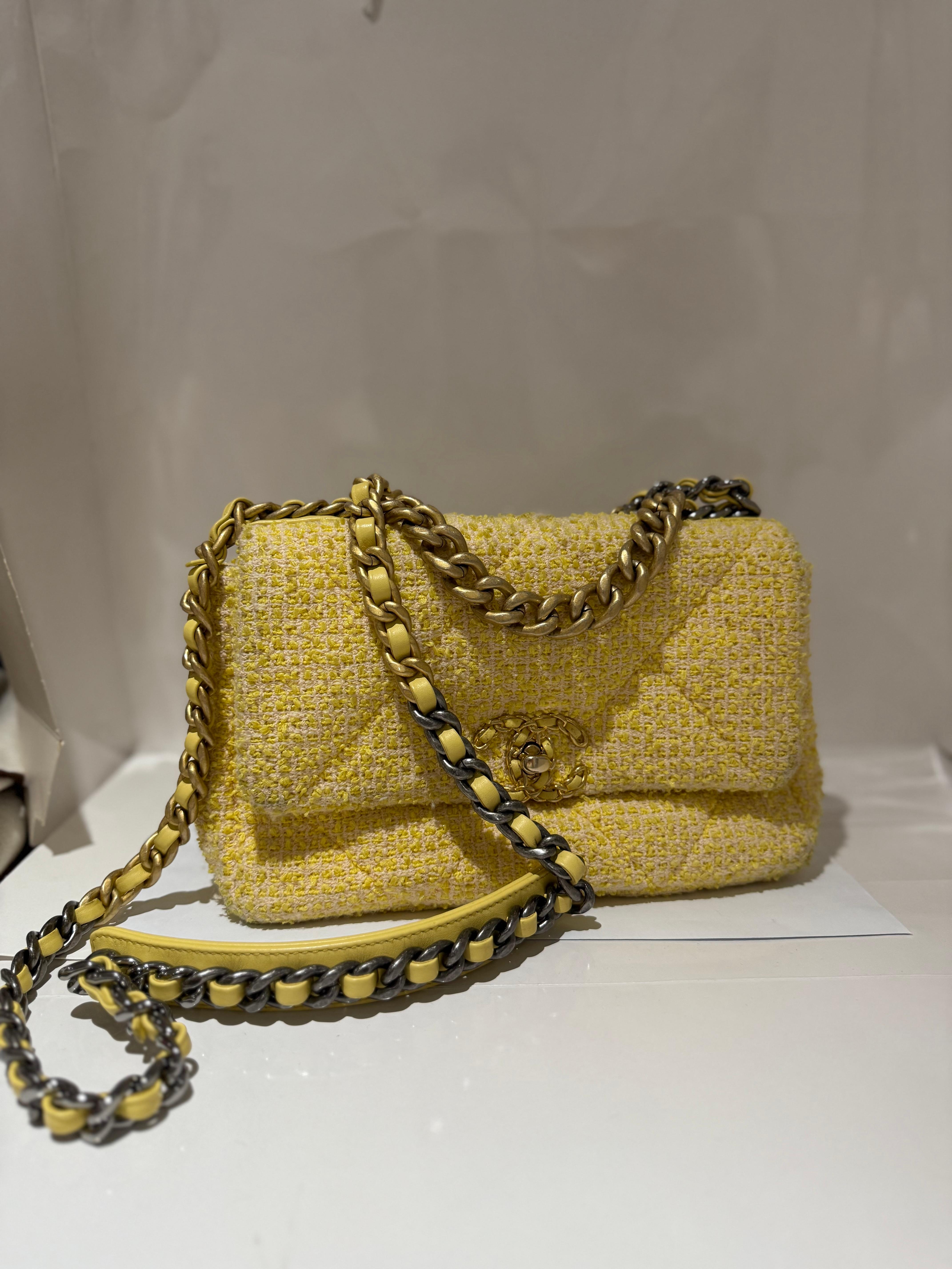 Chanel Tweed Acolchado Mediano Chanel 19 Solapa en Amarillo. Esta suave bandolera está confeccionada en tweed acolchado de gran tamaño en amarillo. Este refinado bolso cuenta con un cierre giratorio CC con detalle de cadena en la solapa, un bolsillo