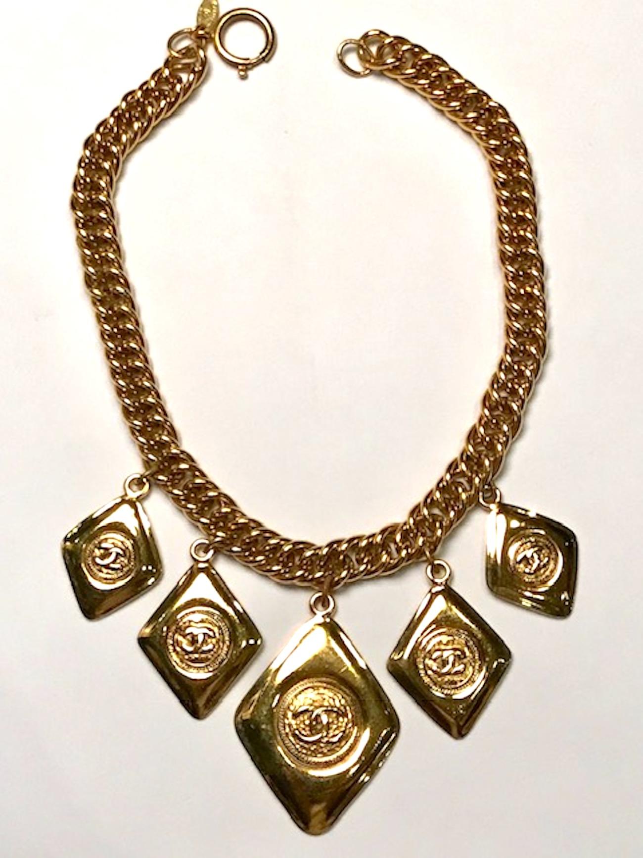 Circa 1980 to 1985 is this statement Chanel necklace with five five diamond pendant  charms. Each charm has the Chanel double CC logo in a round stamp on diamond pendant. The smallest charm is 1 1/8