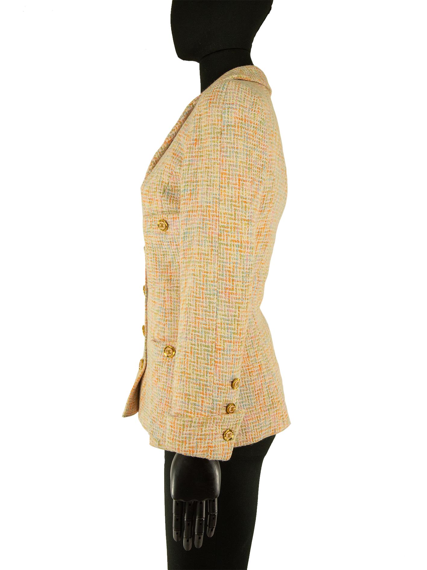 A Chanel jacket from the 1980s, in orange, pink, blue and green check tweed. The bodice is sewn with tailored princess seams making the silhouette fitted. The neckline is wide with a standard collar and the jacket also has four front pockets. The