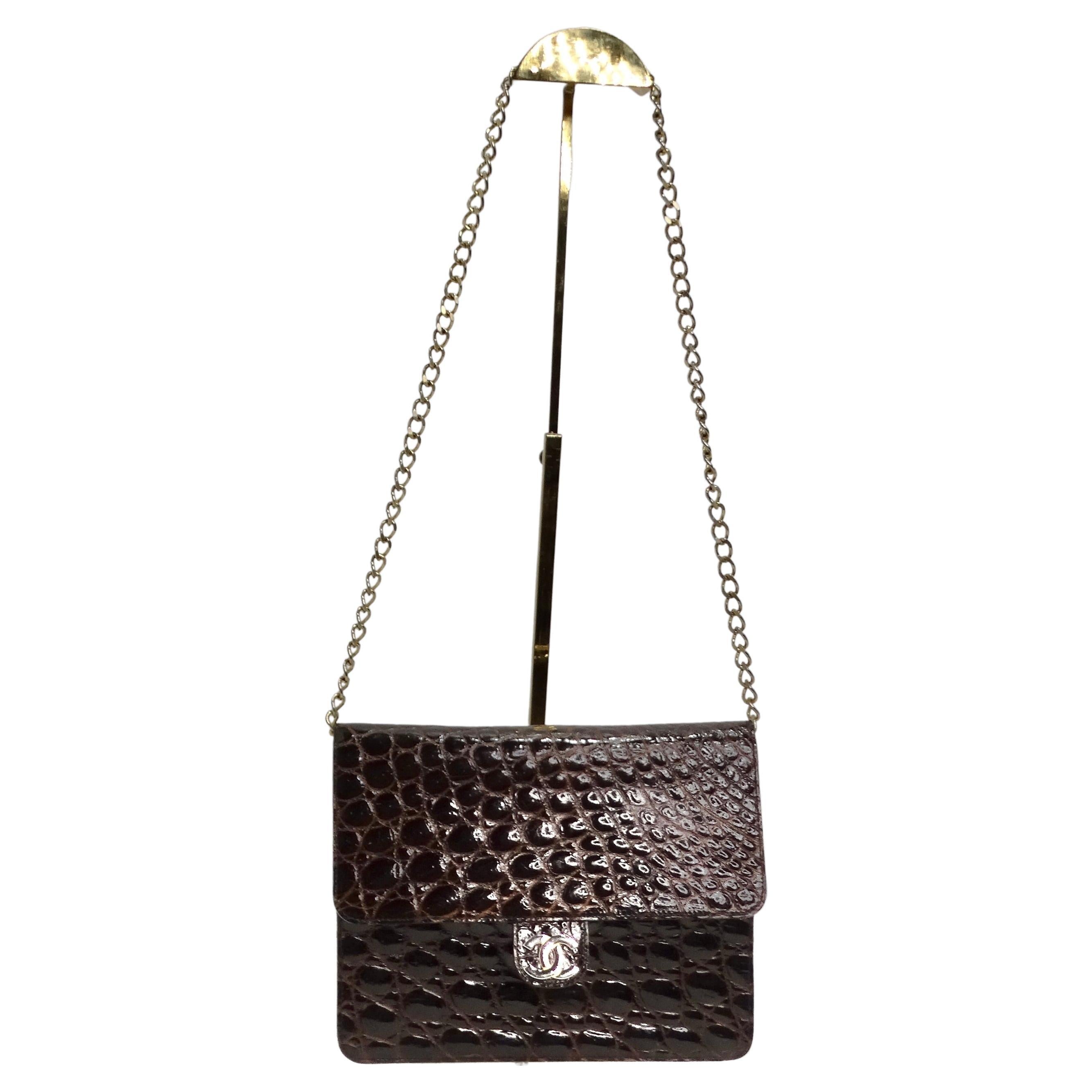 Indulge in luxury with the iconic Chanel 1980s Crocodile Handbag, a classic masterpiece that transcends time. Crafted in the 1980s, this Chanel handbag exudes vintage charm with its classic fold-over style. The rich red-brown crocodile leather