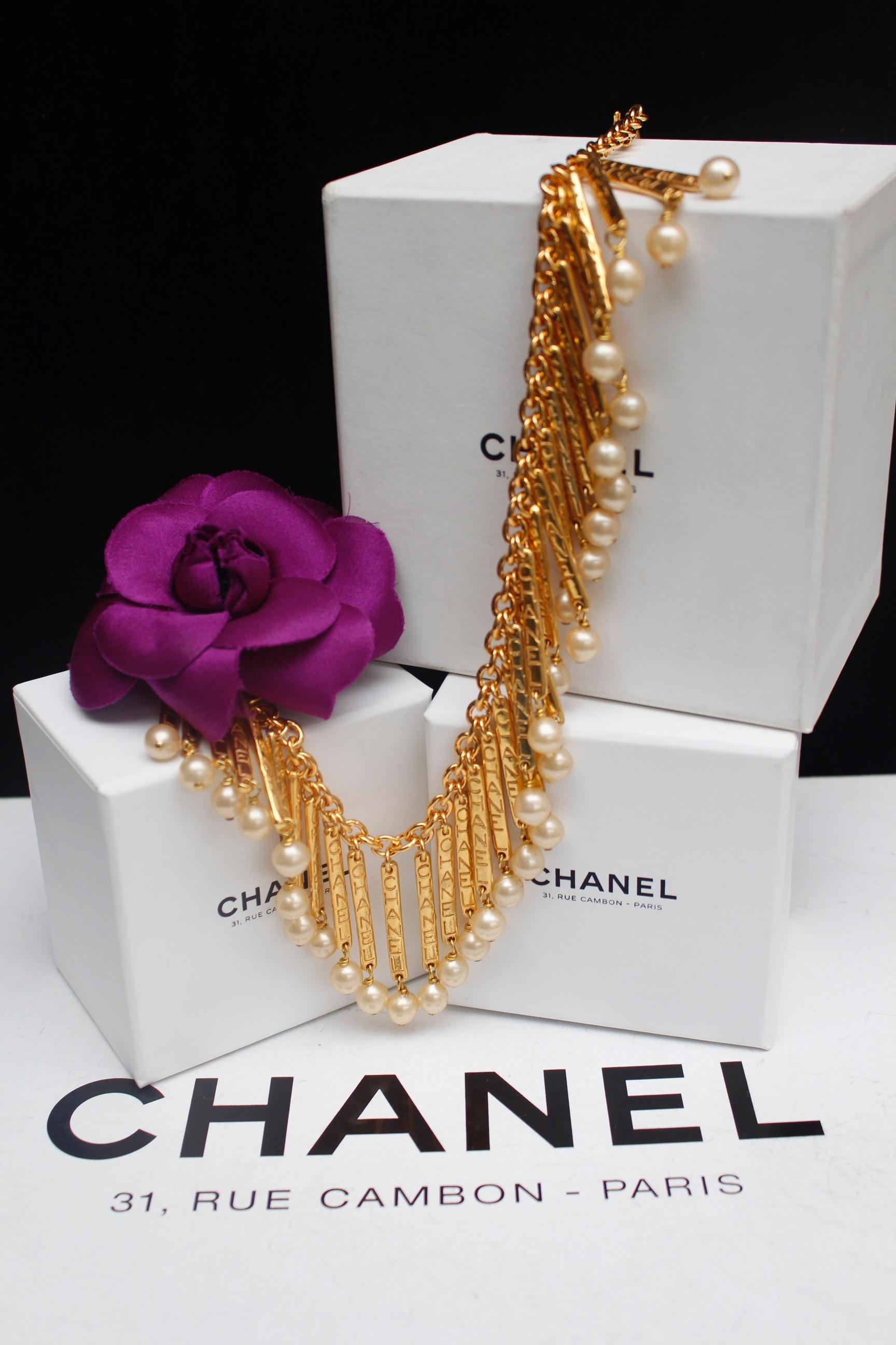 CHANEL (Made in France)

Nice gilted metal chain necklace adorned with along its length with gilted metal sticks hanging a faux pearl. Each stick is engraved with the Chanel inscription.

From the late 1980s.

Length : 16.1 in
 

Very good condition