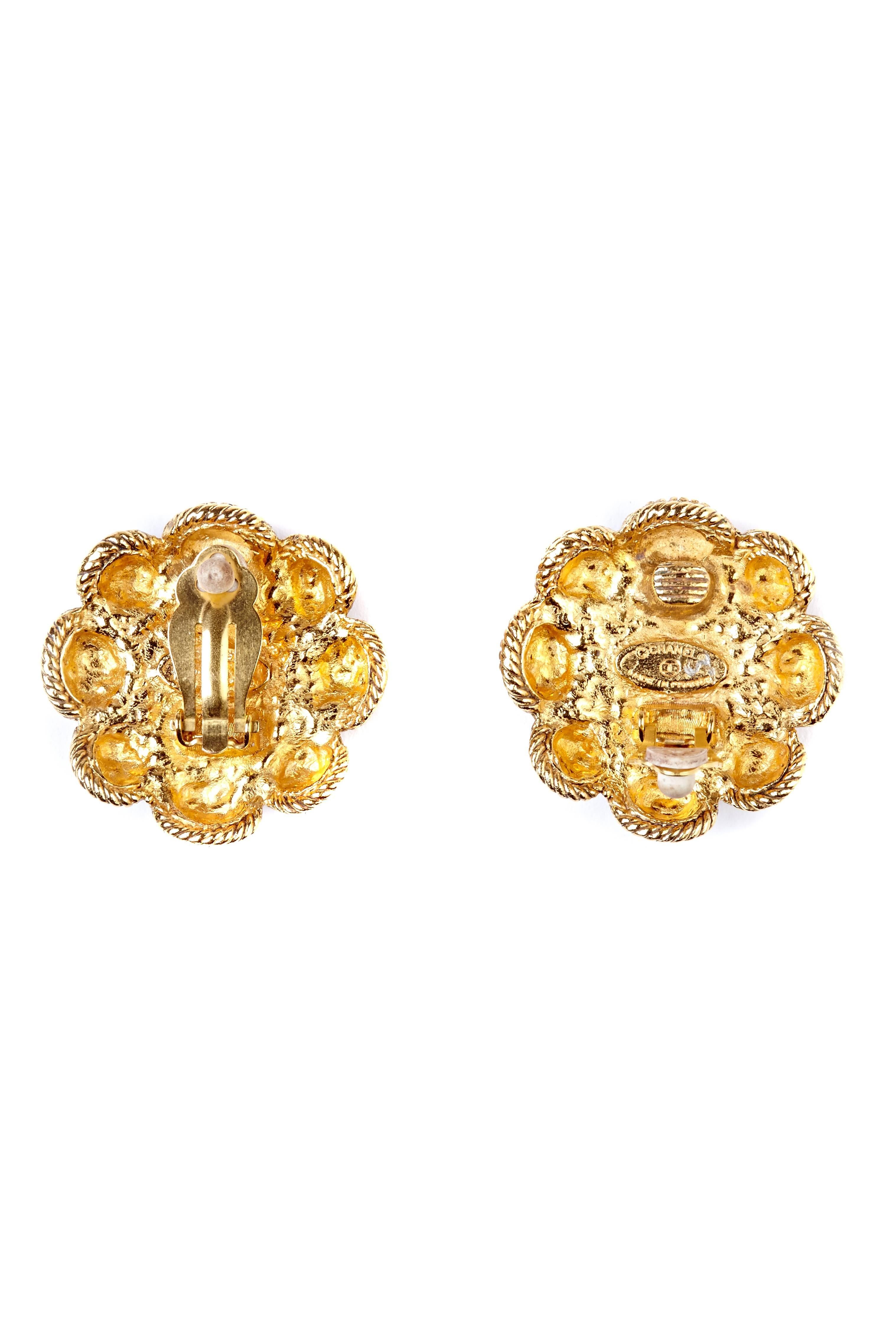 These classic Chanel gold gilt flower earrings are in fabulous condition and will make an impressive addition to any ensemble. The large faux pearl centrepiece measures 0.6 inches and is gently distressed to create a pentagonal shape. It is