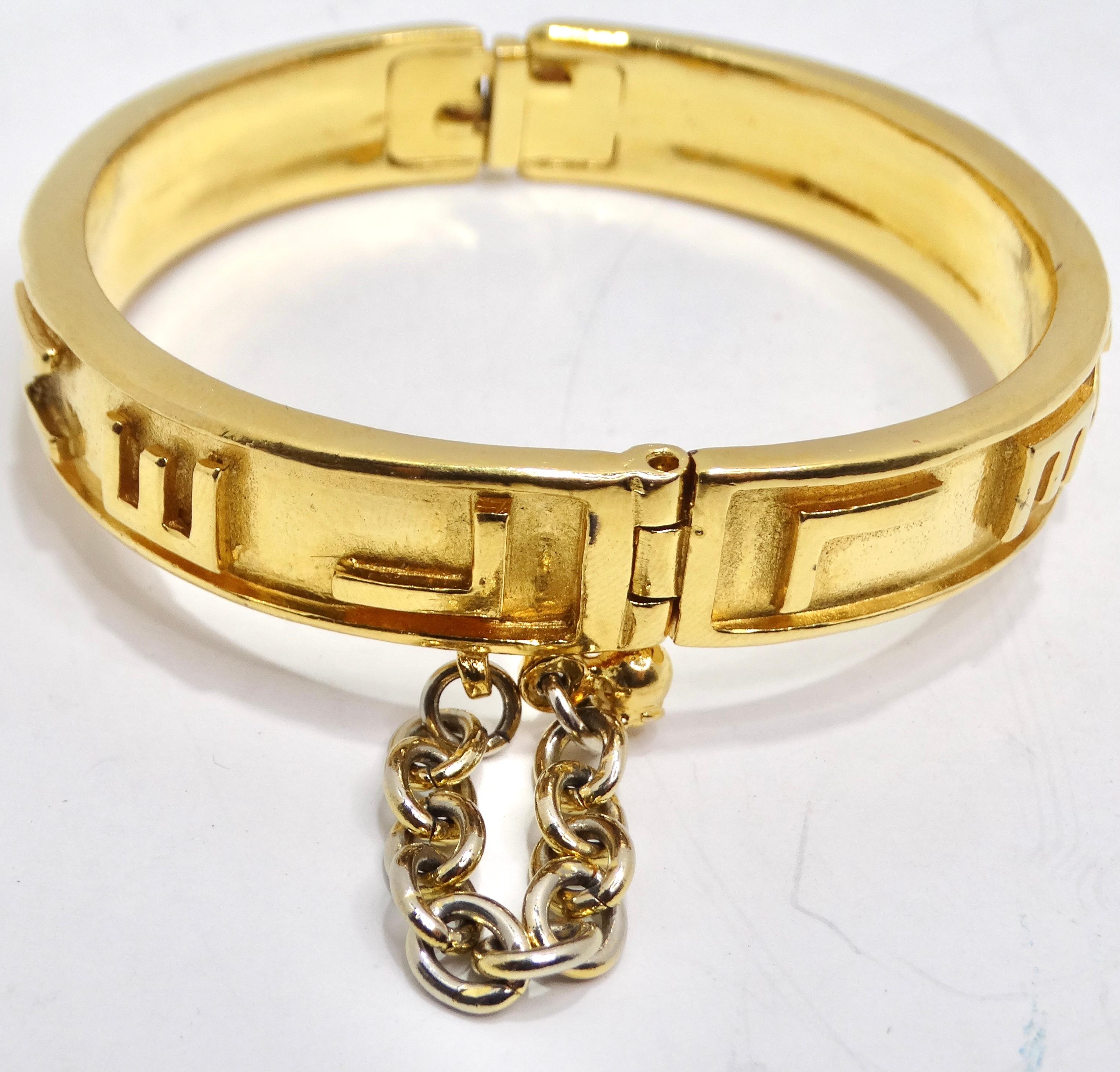 Indulge in the timeless allure of the Chanel 1980s Gold Tone Logo Bangle – a stunning vintage piece that effortlessly captures the essence of sophistication. This beautiful yellow gold plated clamper bangle is not just jewelry; it's a fashion
