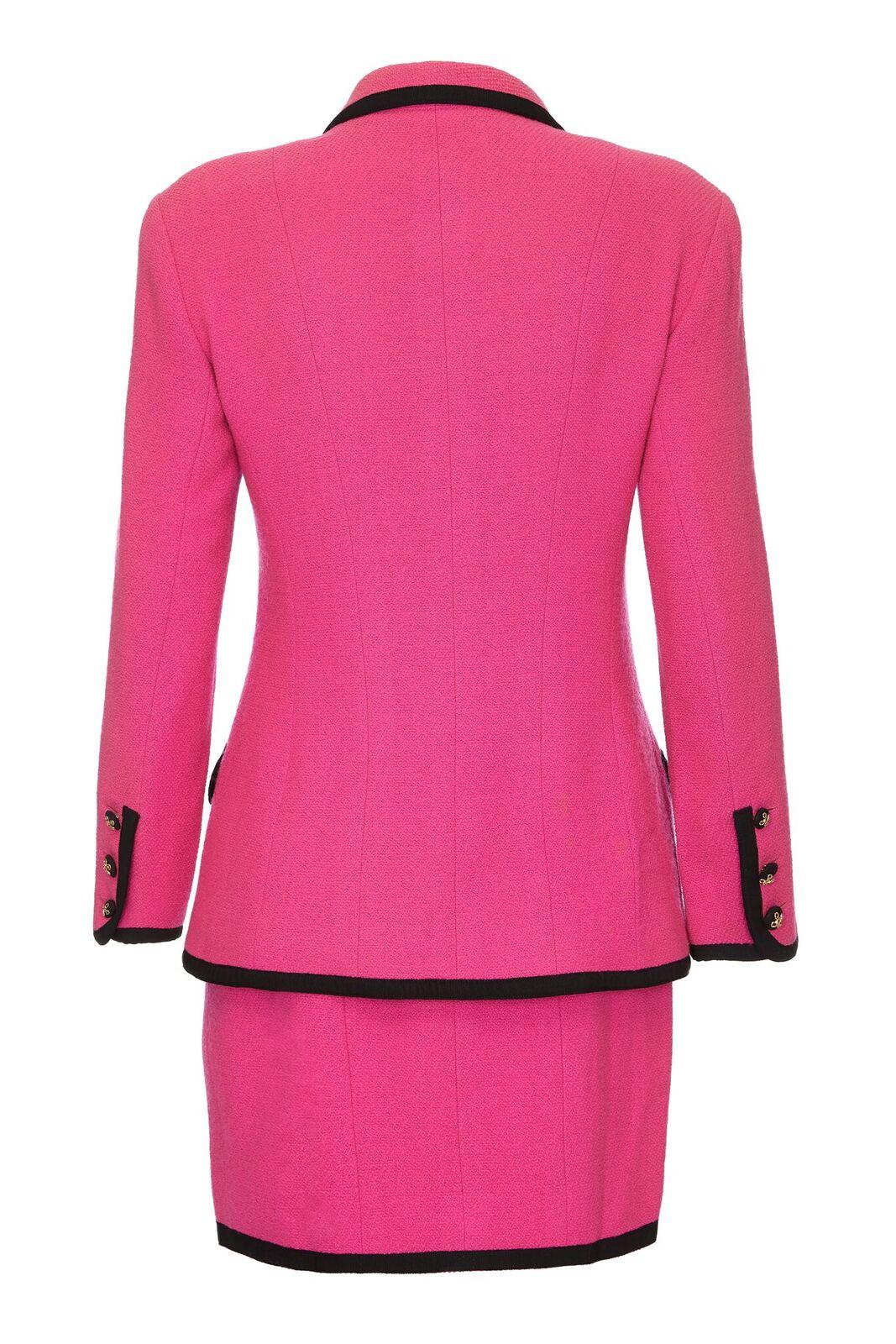This arresting soft wool late 1980s to early 1990s Chanel skirt suit in fuschia pink is in superb condition and is fully lined in soft pink silk with immaculate tailoring. The curved notched lapel falls into a central button stand with 4 x black