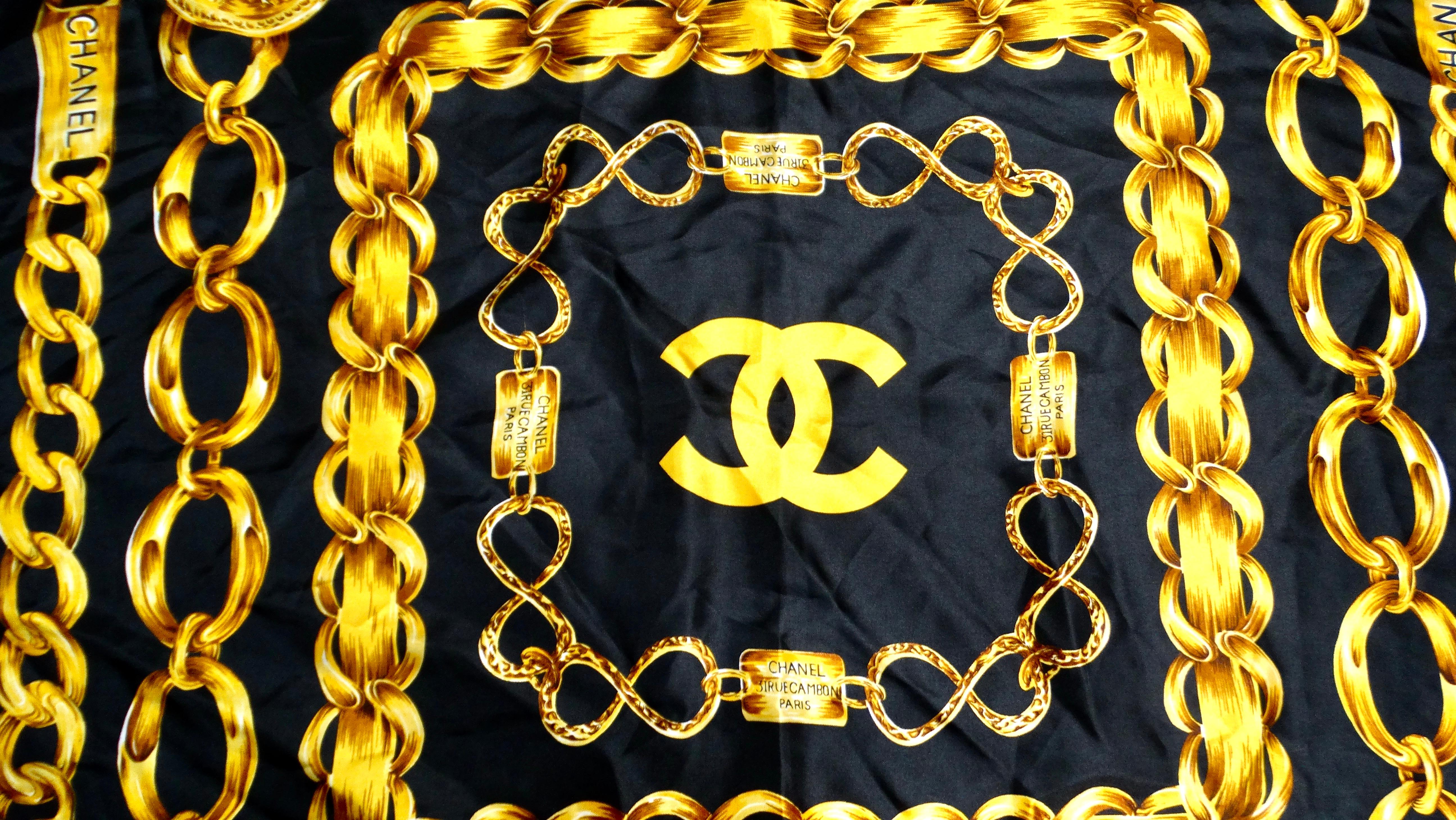 Step into the realm of timeless luxury with this iconic Chanel 1980s Silk Chain Motif Black & Gold Printed Scarf. Crafted from sumptuous silk, this sophisticated accessory features a striking black backdrop adorned with an intricate gold chain